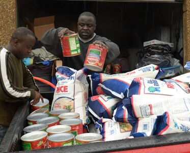 U.S. Army Sgt. Joel Appiah, 510th Human Resource Company, 53rd transportation Battalion, 7th Transportation Brigade (Expeditionary) wheeled vehicle mechanic, and Sgt. 1st Class Francis Aduoffei, McDonald Army Health Center logistics noncommissioned officer-in-charge, load canned goods and bags of rice into a truck to take to a cargo shipment container in Newport News, Va., Dec. 24, 2014. Aduoffei’s friends from Ghana volunteer to help pack the container once he has collected enough donations to fill it. (U.S. Air Force photo by Staff Sgt. Teresa J. Cleveland/Released)