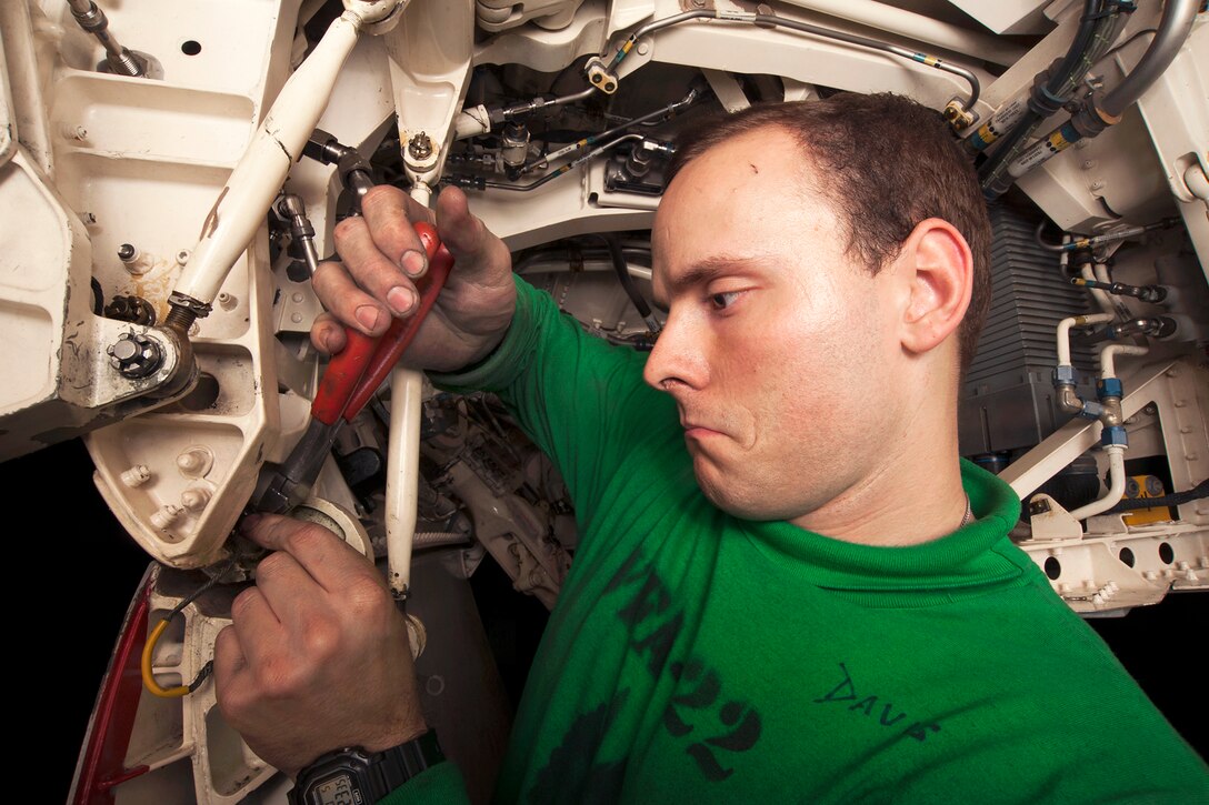 U.S. Navy Petty Officer 3rd Class Kaleb Davis conducts maintenance in the hangar bay of the aircraft carrier USS Carl Vinson in the U.S. 5th Fleet area of responsibility, Jan. 5, 2015. Davis is an aviation structural mechanic assigned to Strike Fighter Squadron 22.