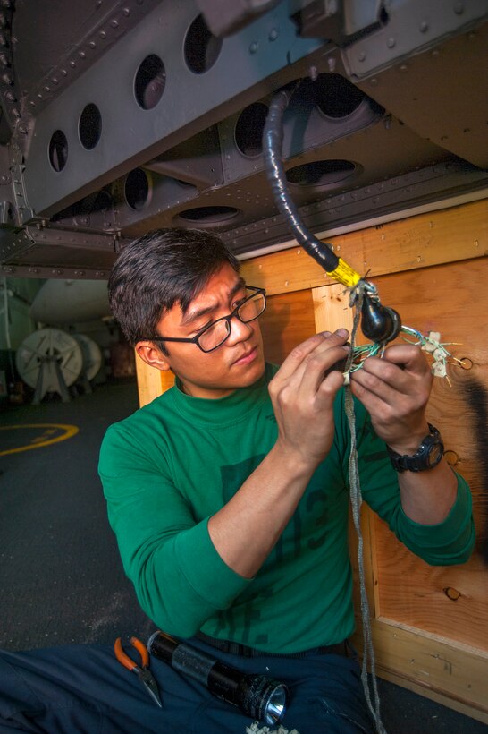 U.S. Navy Petty Officer 3rd Class Joshua Bongar conducts electrical maintenance on an F/A-18C Hornet aircraft canopy in the hangar bay of aircraft carrier USS Carl Vinson in the U.S. 5th Fleet area of responsibility, Jan. 5, 2015. Bongar is an aviation electrician’s mate assigned to Strike Fighter Squadron 113.