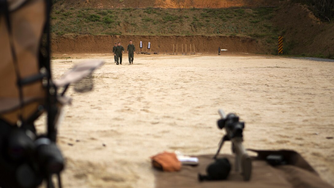 Marines with Special Reaction Team walk to their firing positions after setting up targets during M110 semi-automatic sniper system marksmanship/observer training on Range 22 Jan. 6. The Marines train monthly to maintain proficiency with their weapons systems. SRT is part of the Camp Foster Provost Marshal’s Office, Marine Corps Installations Pacific - Marine Corps Base Camp Butler. SRT is the military equivalent of Special Weapons and Tactics teams. (U.S. Marine Corps photo by Sgt. Matthew Callahan)