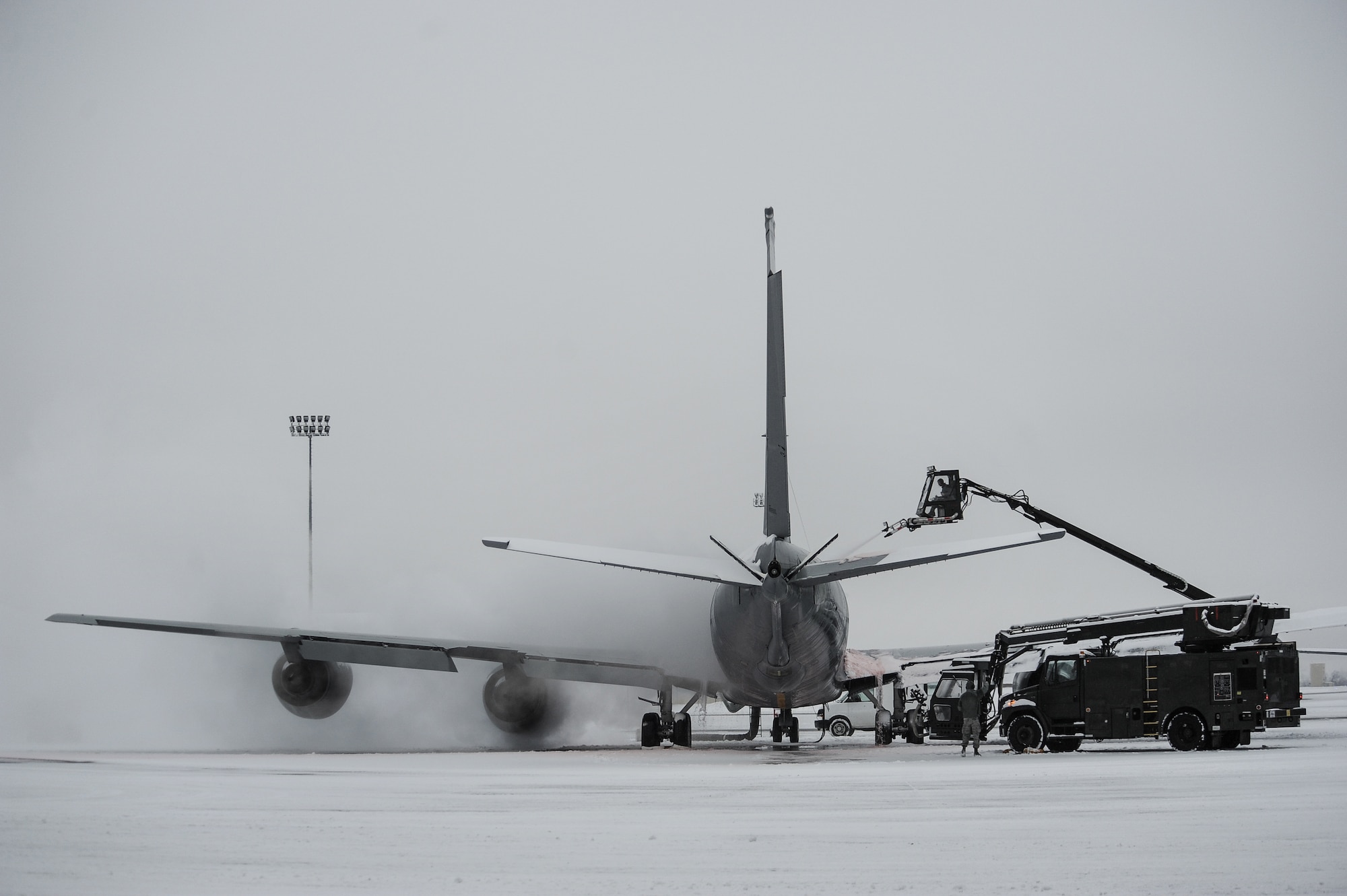 Airmen from the 92nd Aircraft Maintenance Squadron work together to deice a KC-135 Stratotanker Jan. 29, 2014, at Fairchild Air Force Base, Wash. Aircraft deicing is a process in which liquid solutions are sprayed onto an aircraft during the winter to both defrost and prevent future precipitation from freezing. Snow and ice on the wings and rear tail component change their shape and disrupt the airflow making it difficult to fly and diminishes fuel economy. (U.S. Air Force photo/Staff Sgt. Alexandre Montes)
