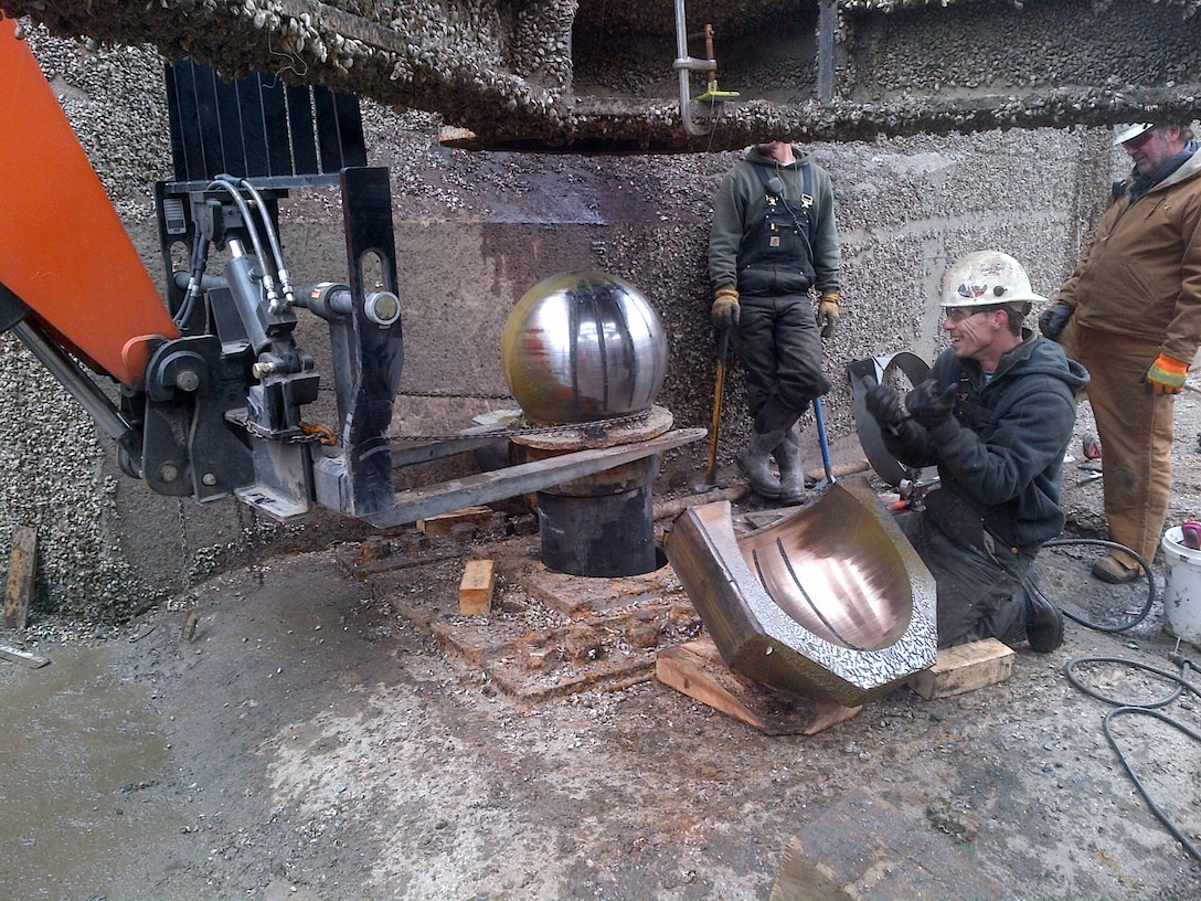 Illinois Waterway Maintenance Crew members, Craig Williams, Cory Bowen and Mark Hanson remove the pintle ball and bushing from the lower right sector gate at T.J. O'Brien Lock.