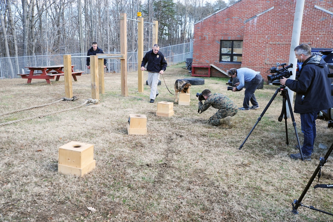 Seasoned military working dog Andy is unfazed by all the cameras as he and his handler, Officer John Boutte, search for drugs in the training boxes at the Marine Corps Base Quantico Provost Marshal’s office kennels on Dec. 17. 