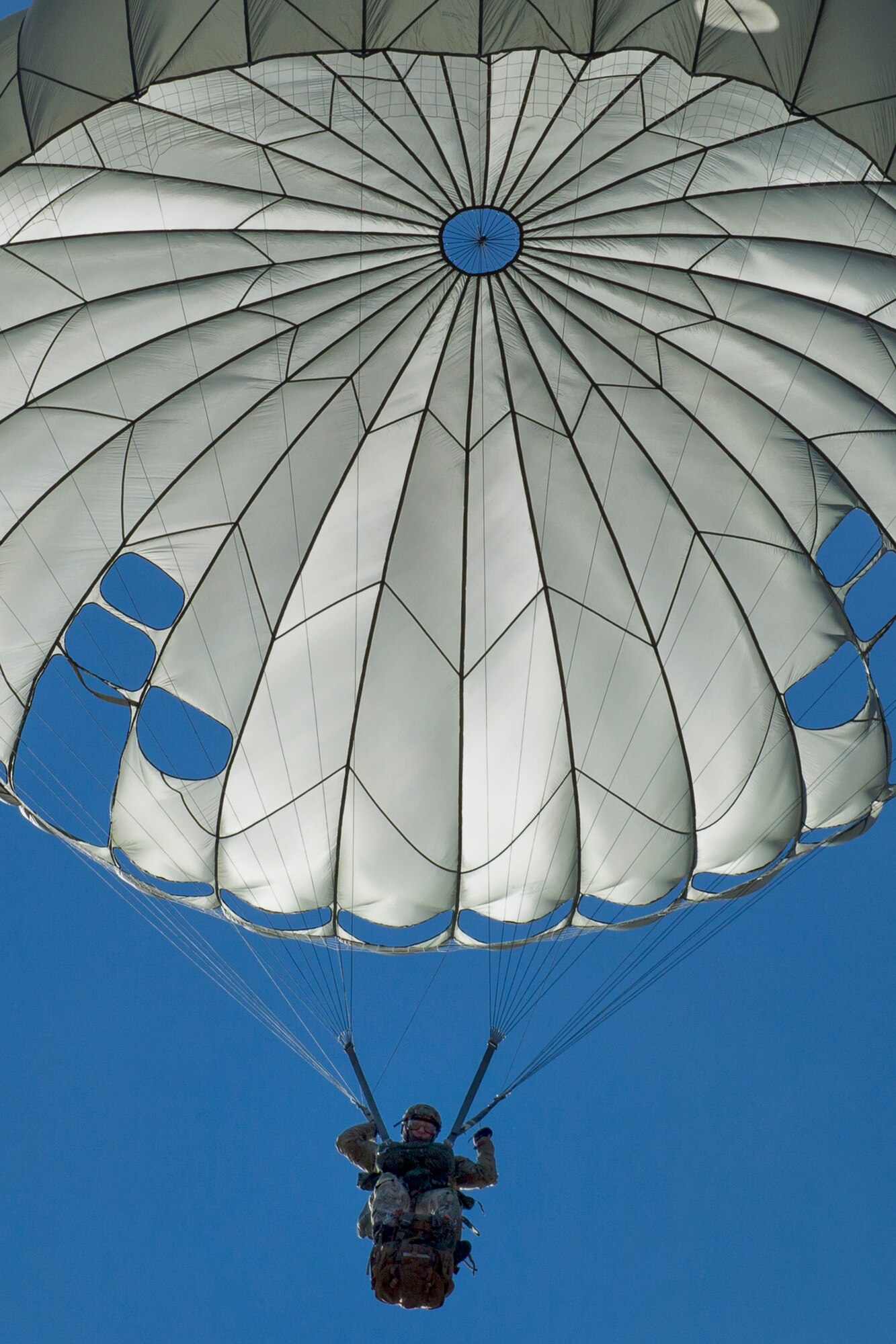 Capt. Vince Koziol, 31st Rescue Squadron flight commander, descend with a parachute after jumping from a 36th Airlift Squadron C-130 Hercules during ‘Jump Week’ at Yokota Air Base, Japan, Jan. 6, 2015. During Jump Week, members of the 31st RQS link up with the 36th AS to maintain mission readiness and rescue tactics in preparation for real-world emergencies. (U.S. Air Force photo by Osakabe Yasuo/Released)
