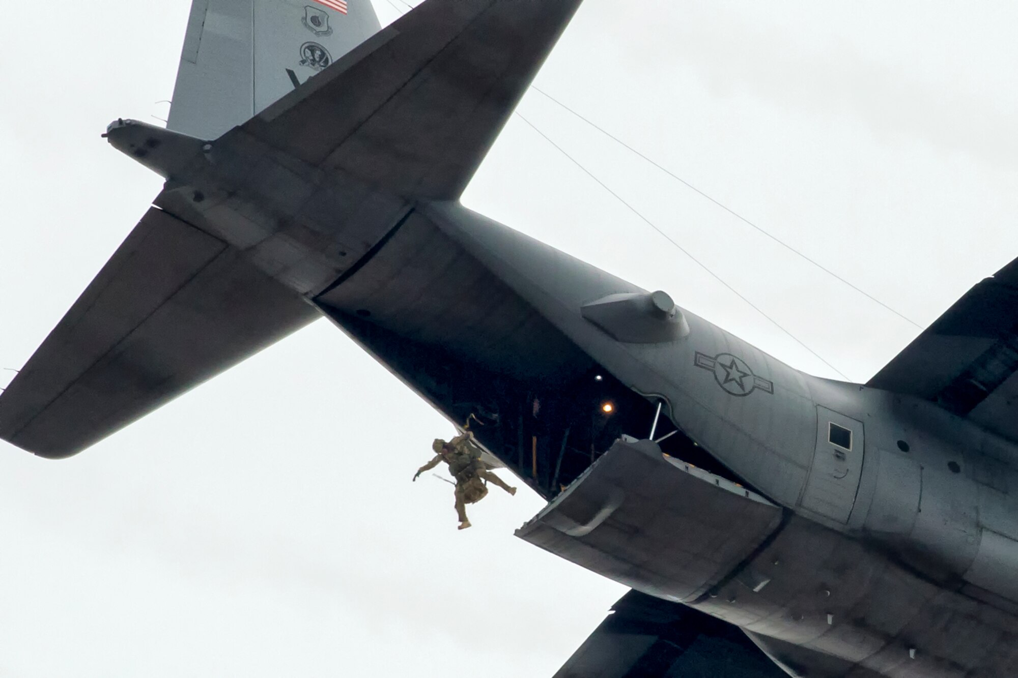 A 31st Rescue Squadron pararescueman jumps out of a 36th Airlift Squadron C-130 Hercules during a training mission over Yokota Air Base, Japan, Jan. 6, 2015. The 36th Airlift Squadron and 31st Rescue Squadron maintain mission readiness for aircrew and pararescuemen. (U.S. Air Force photo by Osakabe Yasuo/Released)