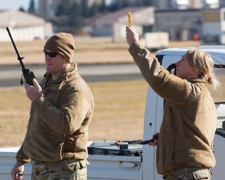(Left to right) Tech. Sgt. Bruce Rick, 31st Rescue Squadron NCO in charge of combat arms, and Tech. Sgt. Kierston Mair, 31st Rescue Squadron NCO in charge of aviation resource management, check the weather and radio that information to the aircraft flying overhead at Yokota Air Base, Japan, Jan. 7, 2015. Airmen from the 31st RQS maintained mission readiness for rescue missions. (U.S. Air Force photo by Osakabe Yasuo/Released) 