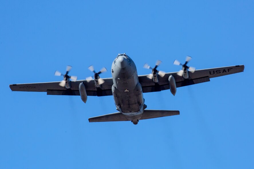 A C-130 Hercules flies over a drop zone at Yokota Air Base, Japan, Jan. 7, 2015. The 36th Airlift Squadron and 31st Rescue Squadron maintain mission readiness for aircrew and pararescuemen. (U.S. Air Force photo by Osakabe Yasuo/Released) 