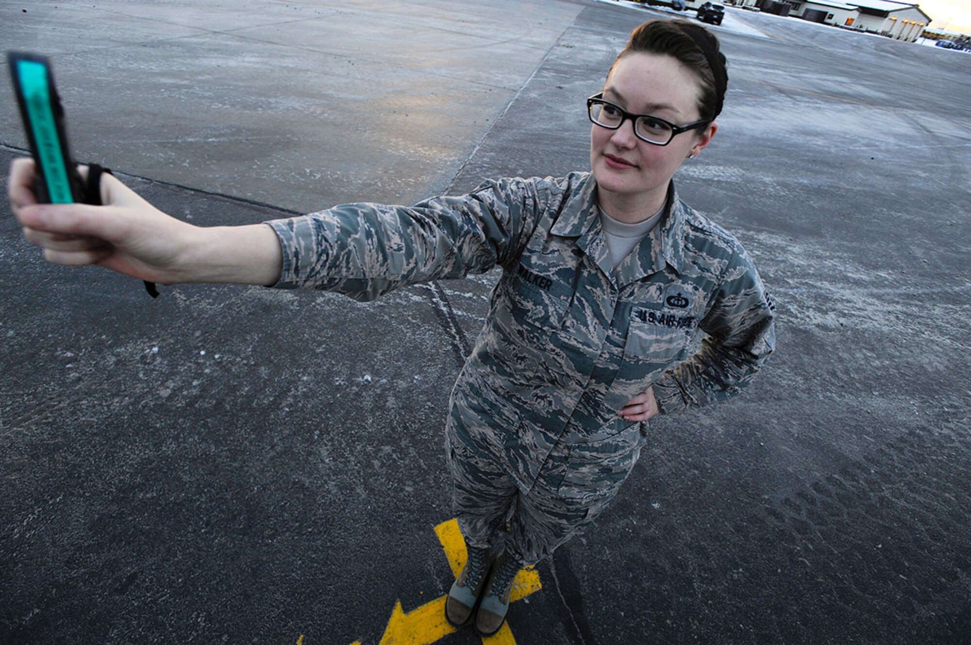 Air Force Staff Sgt. Dana Walker uses a kestrel meter to gauge wind and temperature readings from the official observing location, the most unobstructed view of the airfield, painted on the runway at Joint Base Elmendorf-Richardson, Alaska, Dec. 28. Walker is a weather forecaster assigned to the 3rd Operations Support Squadron. (U.S. Air Force photo/Staff Sgt. Robert Barnett)