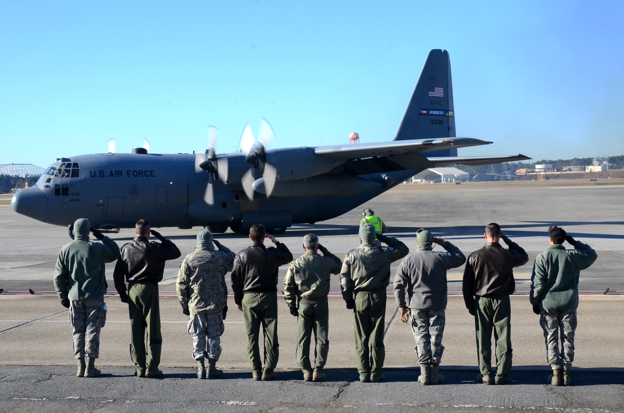 Dobbins Air Reserve Base leadership salute a U.S. Air Force C-130 Hercules as it takes off for a deployment from Dobbins ARB, Ga., Jan. 8, 2015, Ga. More than 150 members from the 94th Airlift Wing deployed to support the Central Command Area of Responsibility. (U.S. Air Force photo/Brad Fallin)