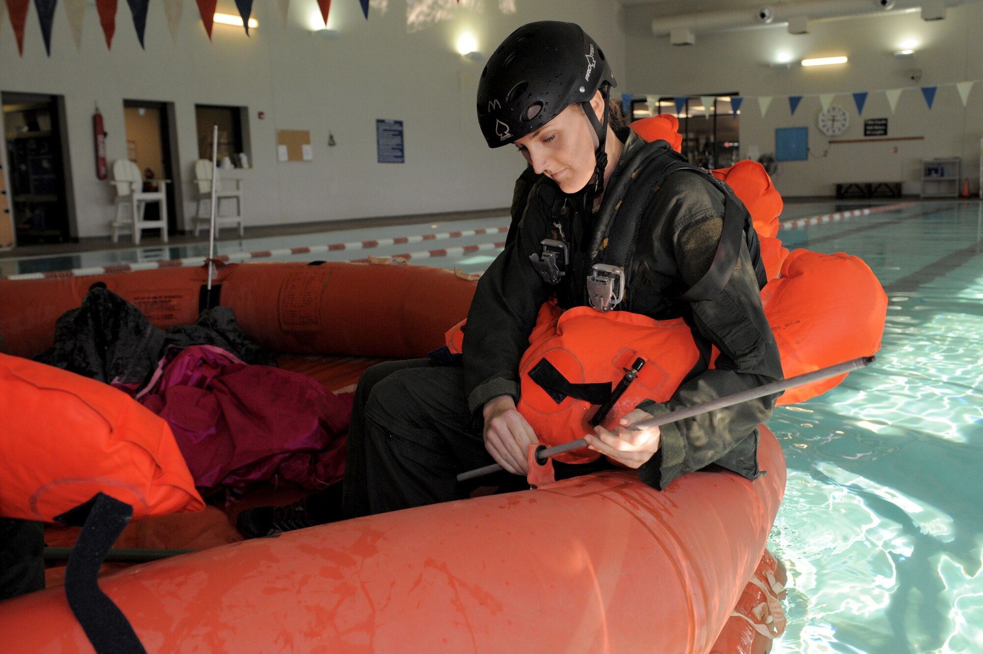 U.S. Air Force Staff Sgt. Whitni Levering, 42nd Electronic Combat Squadron airborne linguist, assembles canopy supports on a life raft during a water survival training refresher course at Davis-Monthan Air Force Base, Ariz., Jan. 5, 2015. When fully assembled, canopies help protect occupants of the life raft from the elements while at sea.  (U.S. Air Force photo by Airman 1st Class Chris Drzazgowski/Released)