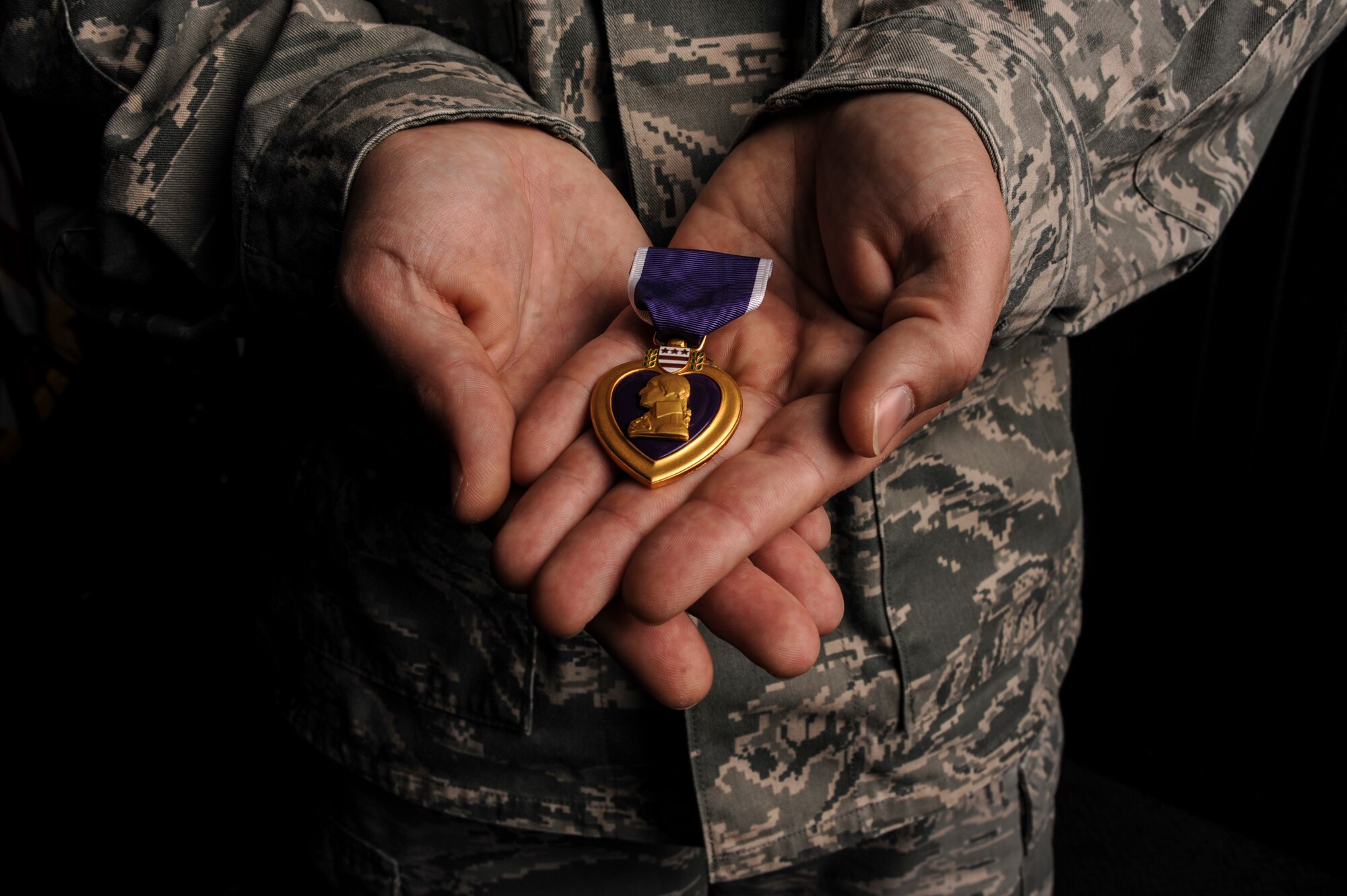 Master Sgt. Aaron Downing, a 19th Security Forces Squadron weapons and tactics superintendent displays his Purple Heart Dec. 10, 2014, at Little Rock Air Force Base, Ark. During his deployment to Iraq in 2007, Downing was wounded when his convoy was attacked by an improvised explosive device. (U.S. Air Force photo by Airman 1st Class Mercedes Muro) 