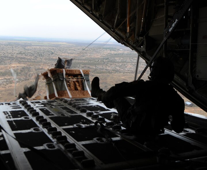 U.S. Air Force Senior Airman Benjamin Baughman, 39th Airlift Squadron loadmaster, kicks a pallet out of a C-130J Super Hercules during the new Impact Day Program Dec. 12, 2014, over Bronte Drop Zone, Texas. The program gives Airmen from the 7th Bomb Wing an inside look at the training the 317th Airlift Group performs in order to be ready to execute the mission. This program was designed to strengthen ties between the 317th AG and the 7th BW. (U.S. Air Force Photo by Airman 1st Class Autumn Velez/Released)