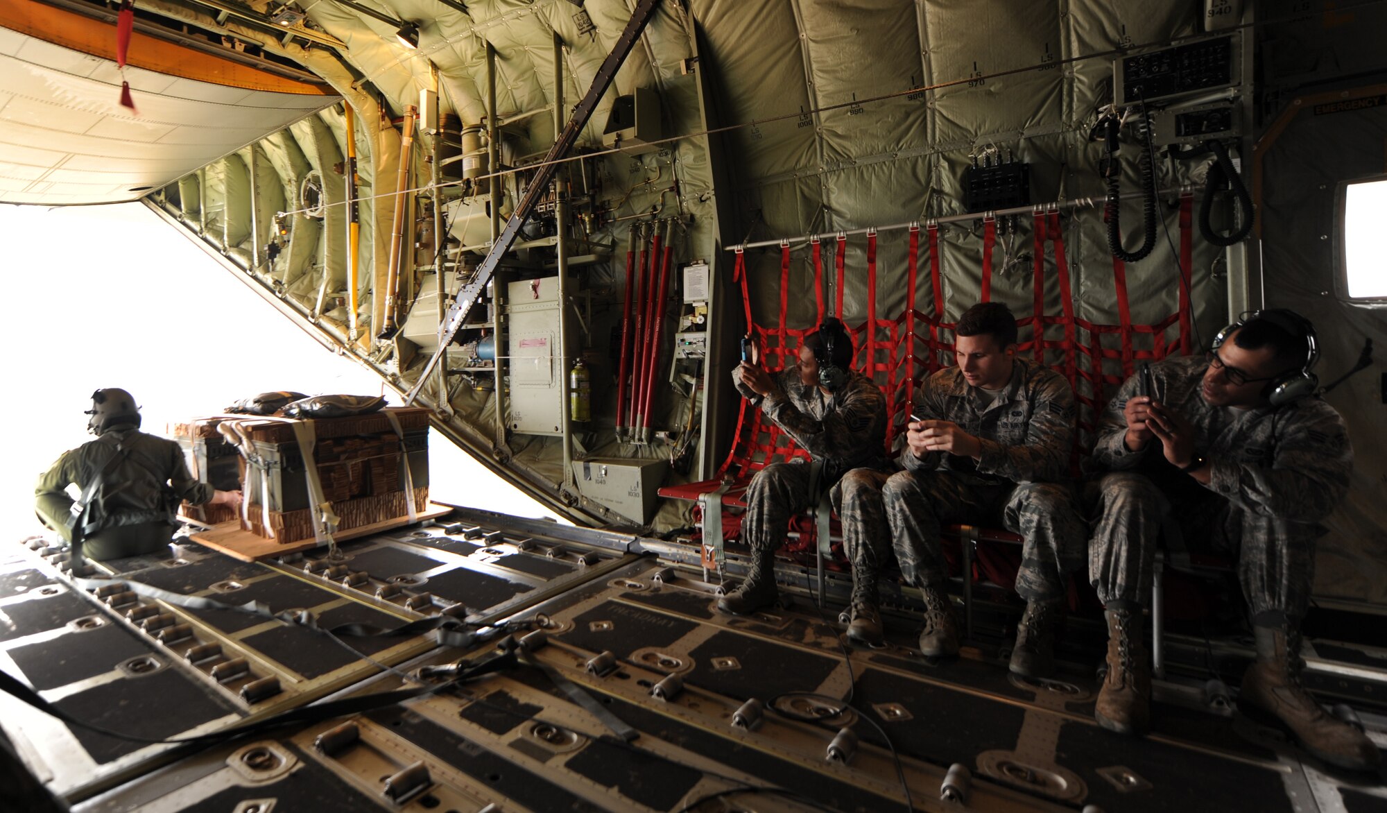 U.S. Air Force Airmen from the 7th Bomb Wing watch a loadmaster from the 317th Airlift Group, prepare to perform an airdrop from a C-130J Super Hercules from Dyess Air Force Base during a new Impact Day Program Dec. 12, 2014, over Bronte Drop Zone, Texas. The program gives Airmen who perform support roles an inside look at the operations of the 317th AG. During a flight, Airmen were given the opportunity to experience tactical maneuvers in a C-130J Super Hercules. (U.S. Air Force photo by Airman 1st Class Autumn Velez/Released)