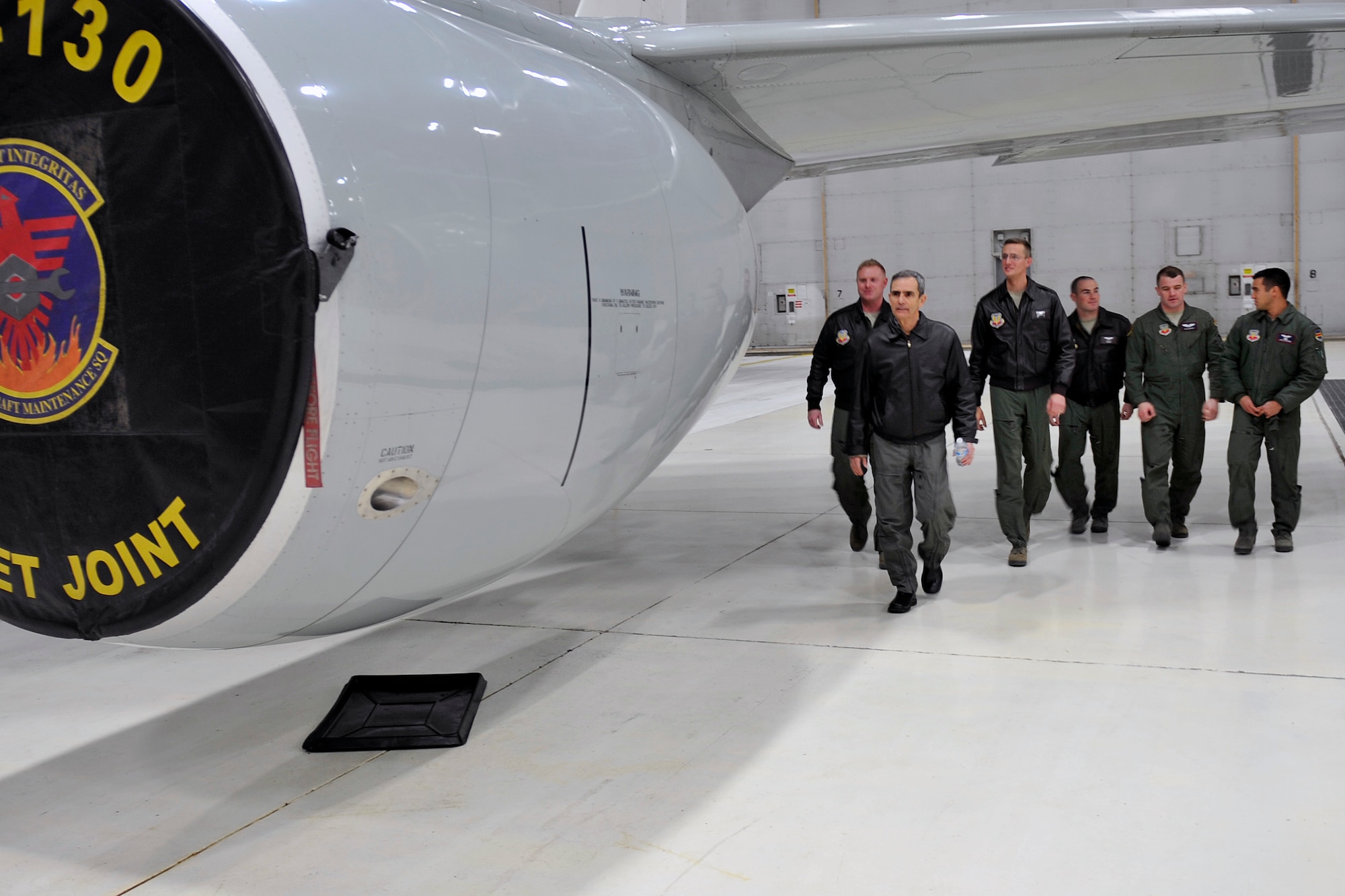 Retired U.S. Air Force Col. Leon “Lee” Ellis, a former prisoner of war and author of the book, ‘Leading with Honor,’ walks with RC-135 crew chiefs while receiving a tour of an RC-135 at Offutt Air Force Base, Neb. Jan 5, 2015. Ellis spoke about his experience as a prisoner of the Vietnam War, and the lessons he learned in resiliency and leadership. (U.S. Air Force photo by Jeff W. Gates/Released)