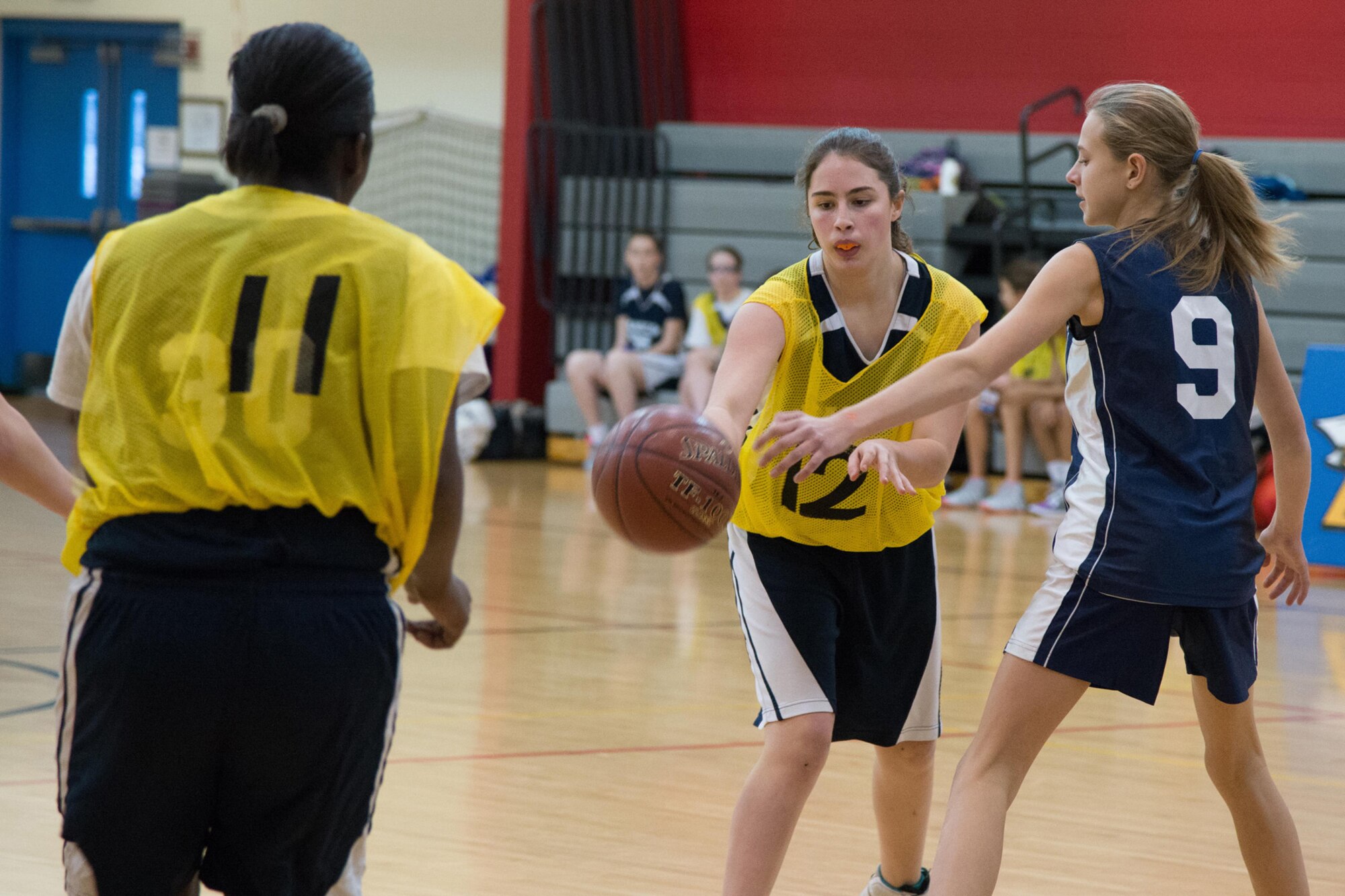 Megan McKenna, a seventh grader for the Hanscom Middle School Falcons girls' basketball team, makes a pass to her teammate, Lyjeria Bryant, also a seventh grader, during a middle school basketball game against Carlisle Middle School at the Hanscom Fitness and Sports Center, Jan. 6. The HMS girls’ team fell to Carlisle 34 to 14. (U.S. Air Force photo by Mark Herlihy)
