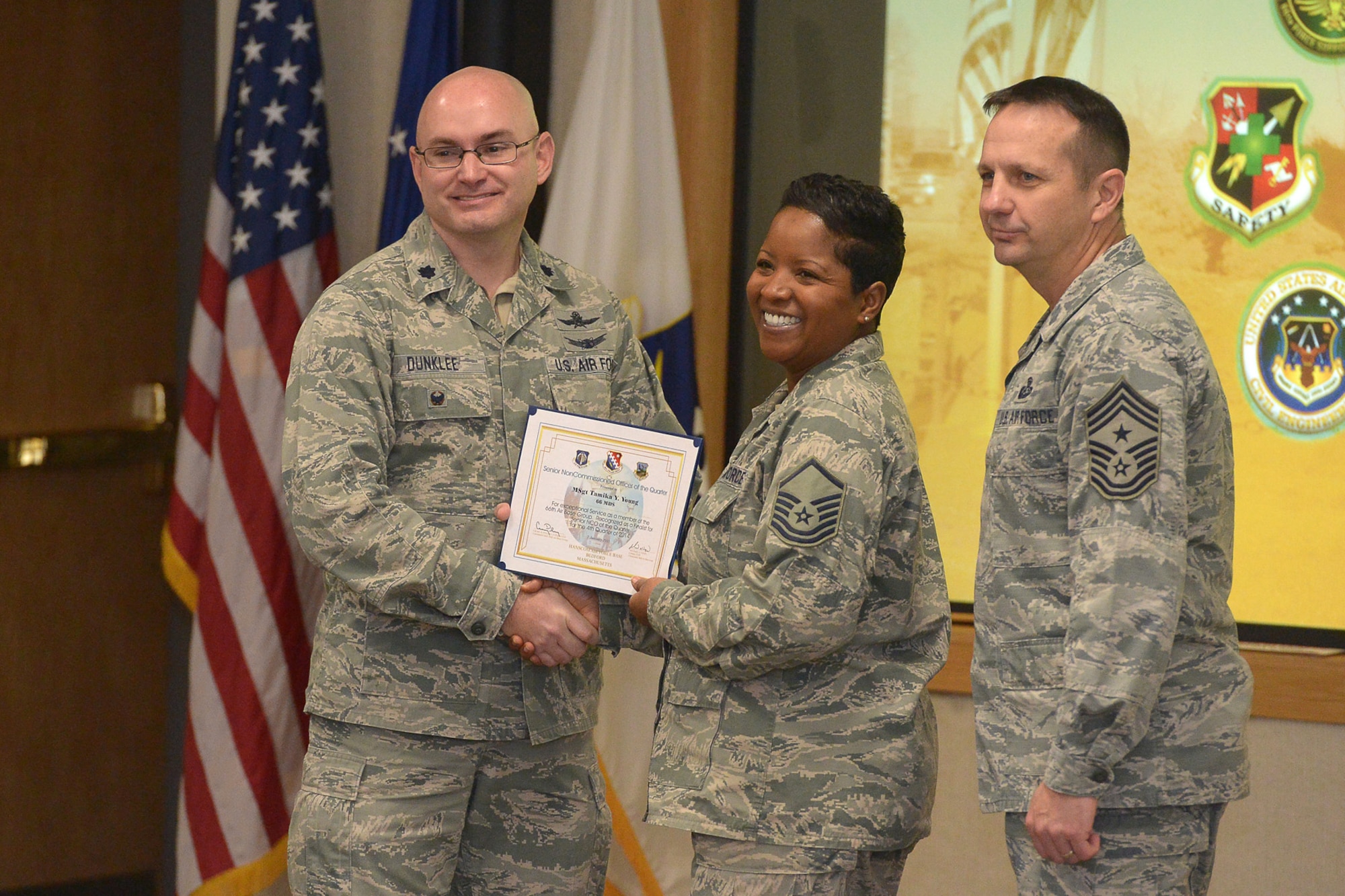 Lt. Col. David Dunklee, 66th Air Base Group deputy commander, and Hanscom Air Force Base Command Chief Master Sgt. Craig Poling, pose for a photo with Senior NCO Nominee Master Sgt. Tamika Young, 66th Medical Squadron Pharmacy Services NCO in charge, during the group’s fourth quarter awards ceremony at the Hanscom Conference Center, Jan. 7. The ceremony recognizes the performance of the military and civilian personnel who displayed exceptional service in the performance of their duties throughout the last quarter. (U.S. Air Force photo by Jerry Saslav)