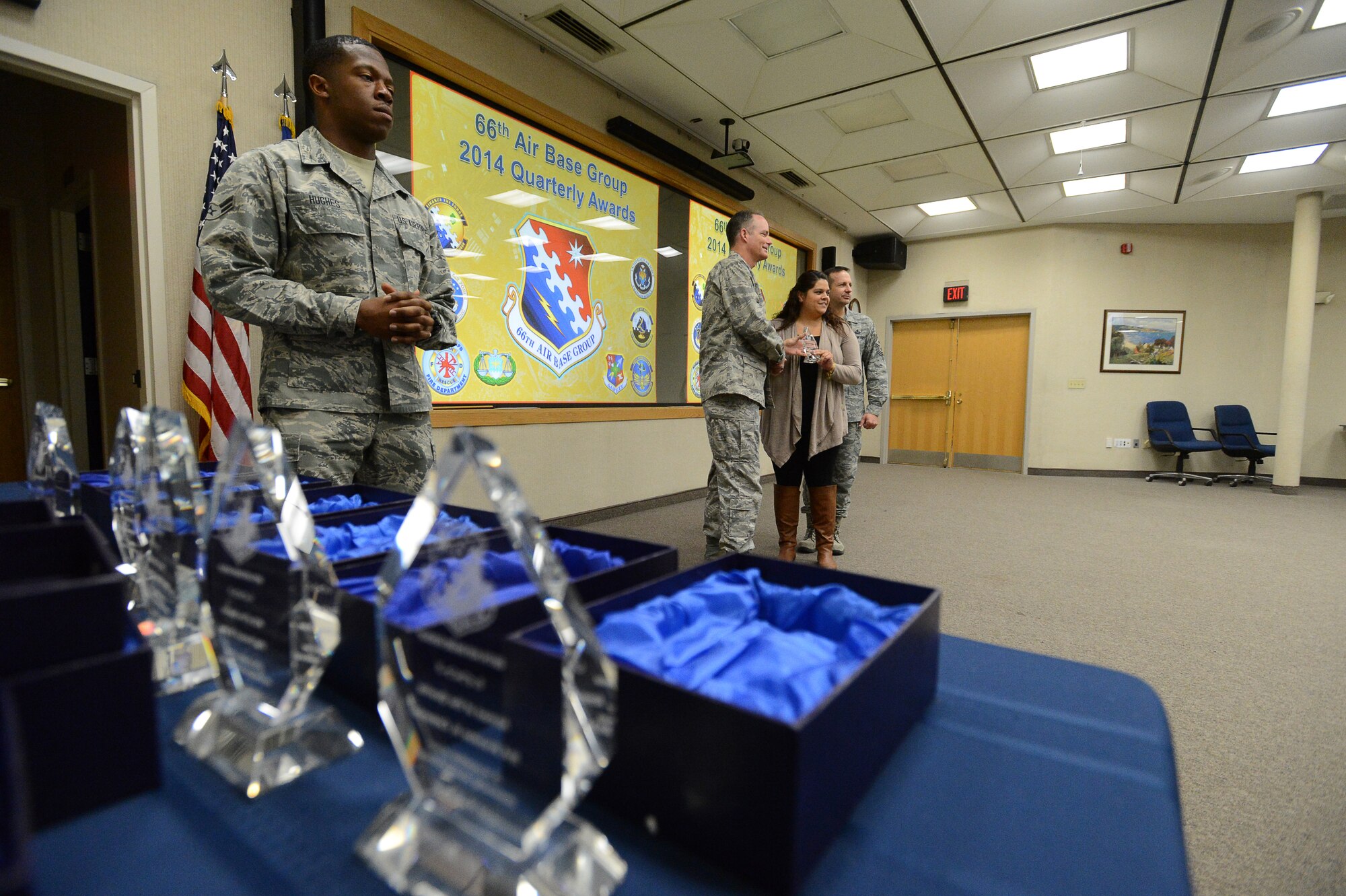 Col. Mike A. Vogel, 66th Air Base Group commander, and Hanscom Air Force Base Command Chief Master Sgt. Craig A. Poling, pose for a picture with the Civilian of the Quarter Category 1 award winner Shana Wickham, 66th Force Support Squadron teen coordinator, during the group’s fourth quarter awards ceremony at the Hanscom Conference Center Jan. 7. The ceremony recognizes the performance of military and civilian personnel who displayed exceptional performance through October to December 2014. (U.S. Air Force photo by Jerry Saslav)