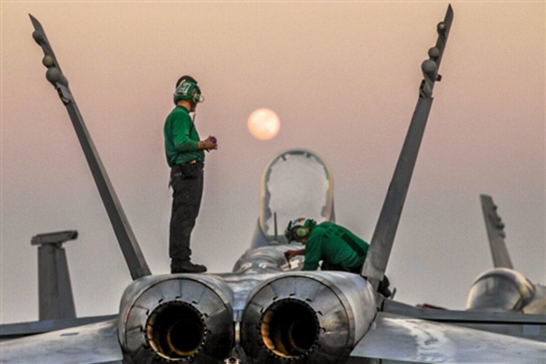U.S. sailors conduct maintenance on an F/A-18C Hornet on the flight deck of the aircraft carrier USS Carl Vinson in the U.S. 5th Fleet area of responsibility, Jan. 4, 2015. The carrier is supporting Operation Inherent Resolve, which includes strike operations in Iraq and Syria as directed. 
 