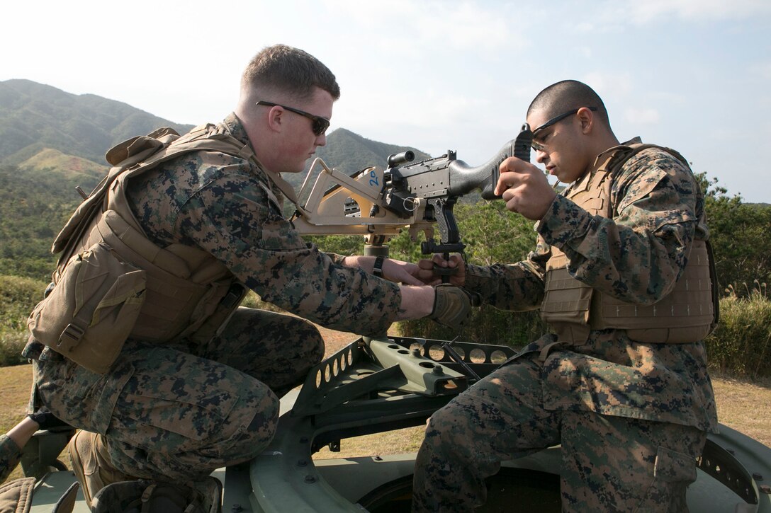 Lance Cpl. Landon R. Beatty, left, and Cpl. Fernando Espinoza mount an M240B medium machine gun to a 7-ton truck during training Jan. 7 at Range 9 in the Central Training Area. The motor transportation Marines practiced the fundamentals of medium machine guns to prepare for the upcoming Integrated Training Exercise 15-2 at Marine Corps Air Ground Combat Center in Twentynine Palms, California. The Marines engaged static targets from distances up to 1,000 feet during this training, increasing confidence in their accuracy with the weapon system. Beatty, from Odenville, Alabama, is a machine gunner with Truck Company, Headquarters Battalion, 3rd Marine Division, III Marine Expeditionary Force. Espinoza, from Phoenix, Arizona, is a motor vehicle operator with the company.
