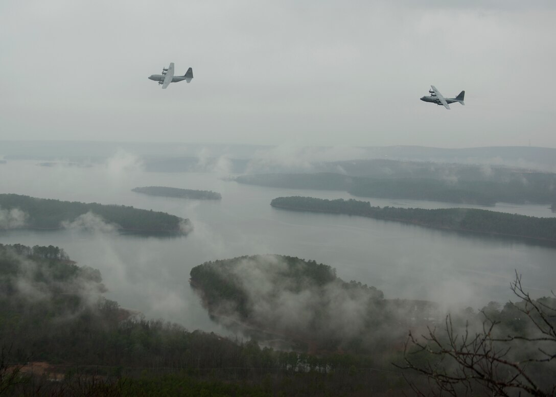 A C-130H Hercules and C-130J Super Hercules participate in an interfly formation flight Dec. 23, 2014, near Pinnacle Mountain State Park in Roland, Ark. The C-130J and C-130H normally fly in separate formations to maximize the performance potential of both aircraft types, but can be employed together in an interfly formation if necessary. (U.S. Air Force photo/Airman 1st Class Scott Poe)