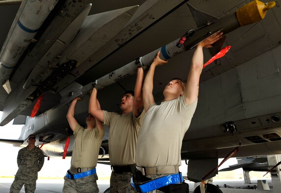 A weapons load crew team from the 44th Aircraft Maintenance Unit work together to lift an AIM-9 Sidewinder missile onto an LAU-128 Missile launcher Jan. 5, 2015, during a quarterly weapons load competition on Kadena Air Base, Japan. The competition tests teams’ abilities to arm F-15 Eagles in a fast and safe manner. The competition was held between the 44th and 67th Aircraft Maintenance Units of the 18th Aircraft Maintenance Squadron. (U.S. Air Force photo/Naoto Anazawa)