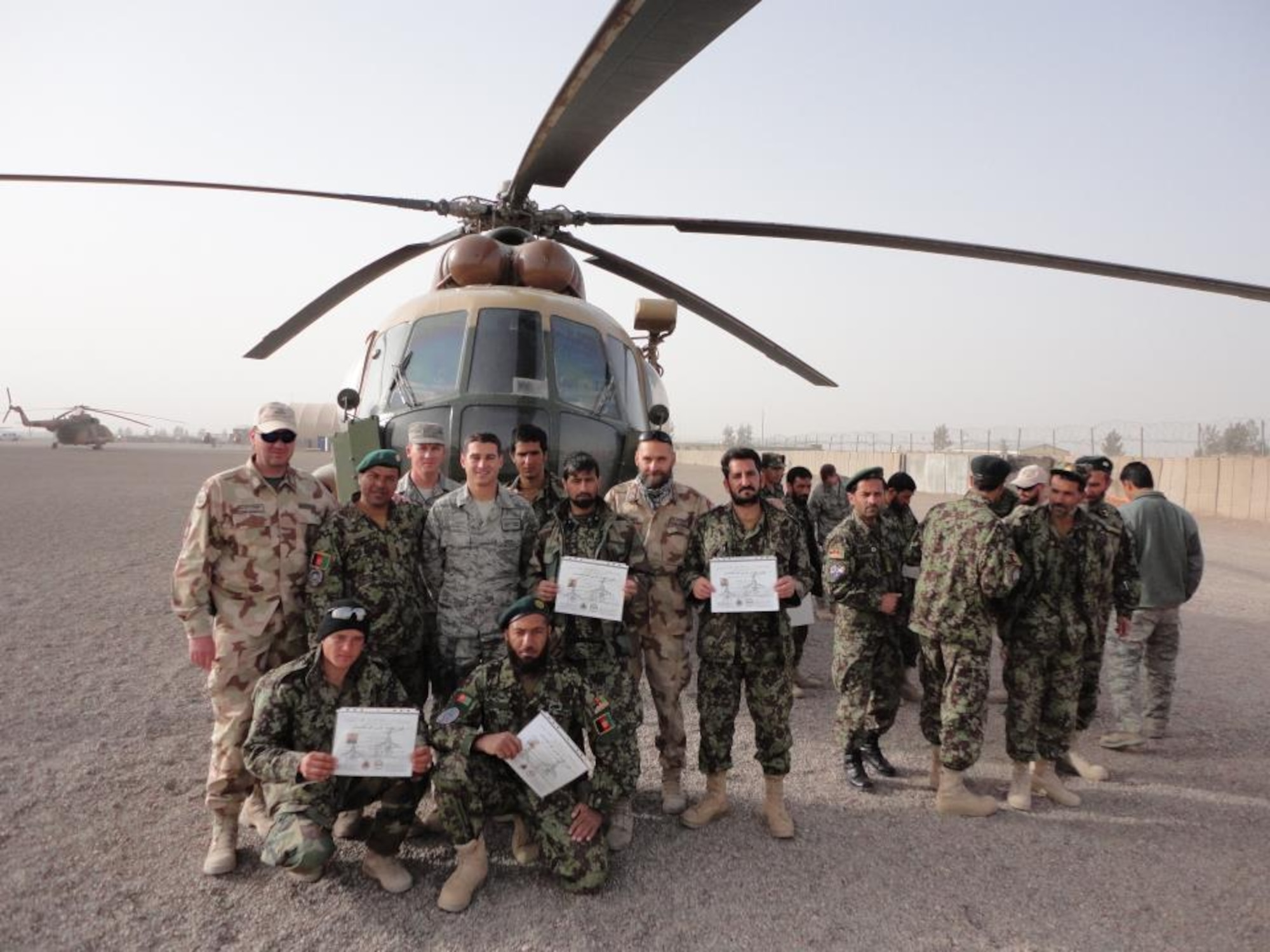 Simon poses with first Afghan Air Force maintainers in 2011 after they received their 3-level upgrade at Shindand Air Force Base, Afghanistan. The maintainers, referred to as "engine body mechanics," had to demonstrate competency of several core maintenance tasks to receive the upgrade. (U.S. Air Force photo)