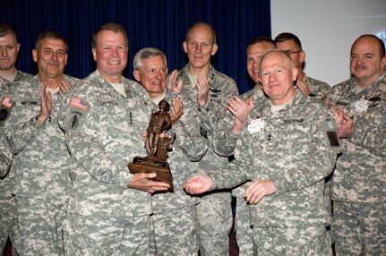 Army Maj. Gen. Raymond Carpenter, the acting director of the Army National Guard, right front, presents a Minuteman Trophy to Army Gen. Charles C. Campbell, the commander of U.S. Army Forces Command during the FORSCOM Command Readiness Program held at Camp Joseph T. Robinson in North Little Rock, Ark., April 20.