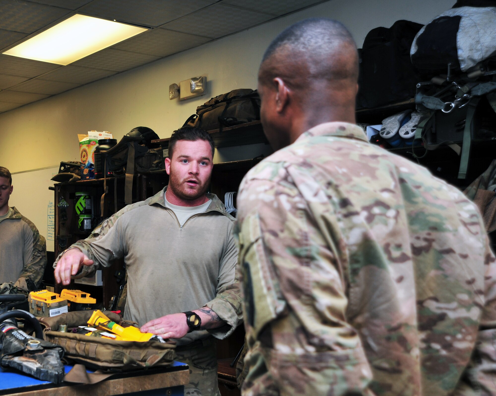 U.S. Air Force Staff Sgt. Kyle Holland, 83rd Expeditionary Rescue Squadron pararescue element leader, briefs U.S. Army Command Sgt. Maj. Christopher Gilpin, Combined Joint Task Force 3 United States Forces Afghanistan, during a tour Jan. 6, 2015 at Bagram Airfield, Afghanistan. During the tour, Gilpin had the opportunity to meet with 455th Air Expeditionary Wing leadership and become better acquainted with Air Force assets and squadrons. (U.S. Air Force photo by Staff Sgt. Whitney Amstutz/released)