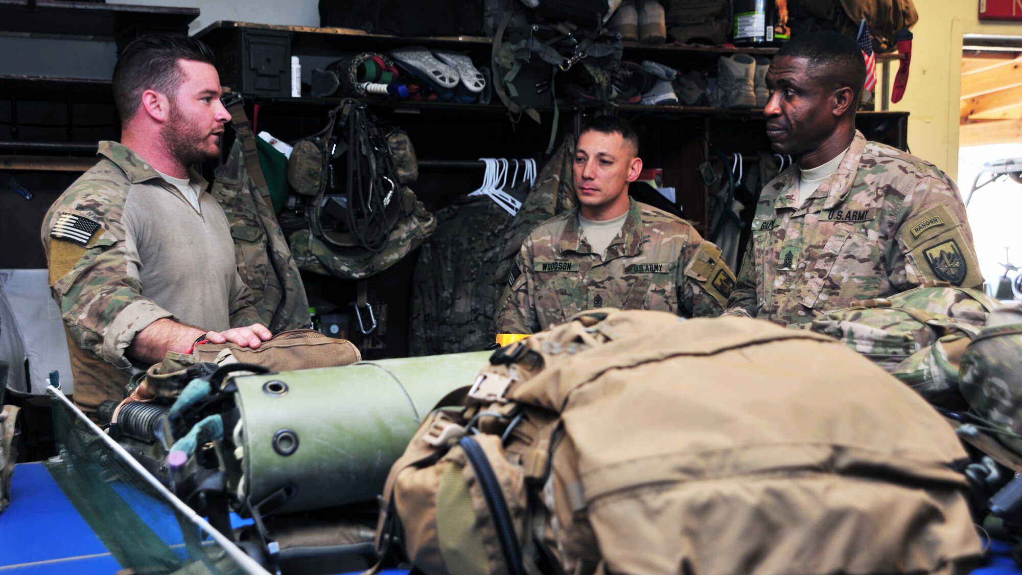 U.S. Air Force Staff Sgt. Kyle Holland, 83rd Expeditionary Rescue Squadron pararescue element leader, briefs U.S. Army Command Sgt. Maj. Christopher Gilpin, Combined Joint Task Force 3 United States Forces Afghanistan, and U.S. Army Sgt. Maj. John Woodson, Combined Joint Task Force 3 United States Forces Afghanistan joint staff operations, during a tour Jan. 6, 2015 at Bagram Airfield, Afghanistan. During the tour, Gilpin and Woodson had the opportunity to meet with 455th Air Expeditionary Wing leadership and become better acquainted with Air Force assets and squadrons. (U.S. Air Force photo by Staff Sgt. Whitney Amstutz/released)