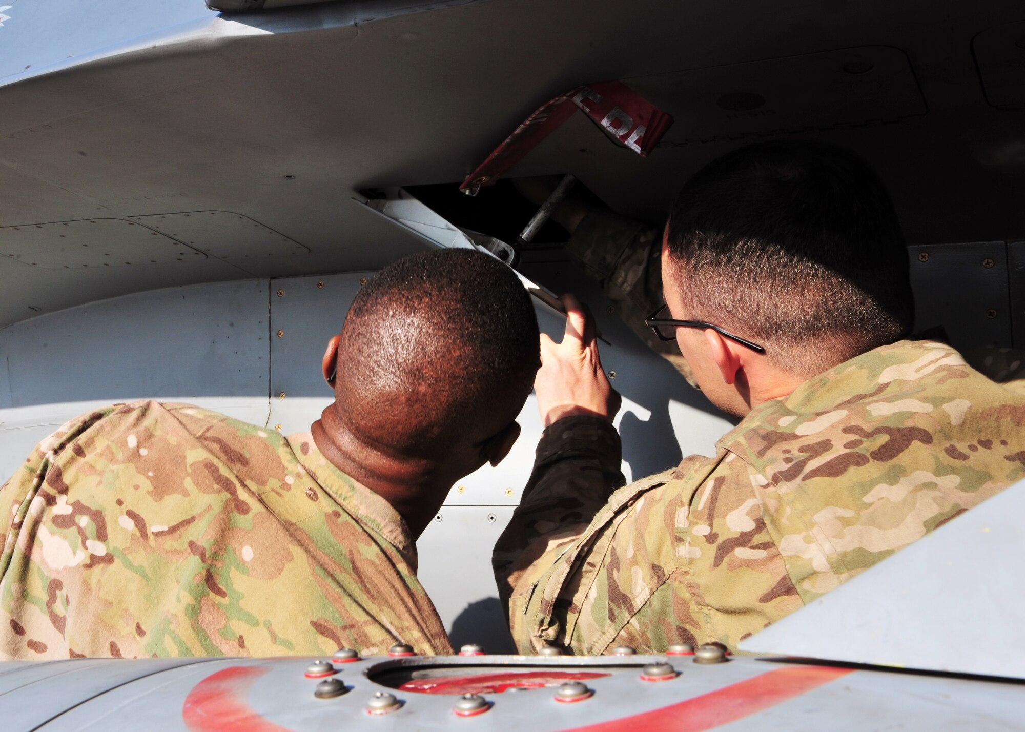 U.S. Air Force Senior Airman Andrew Freire, 455th Expeditionary Aircraft Maintenance Squadron weapons troop, familiarizes U.S. Army Command Sgt. Maj. Christopher Gilpin, Combined Joint Task Force 3 United States Forces Afghanistan, with an aircraft during a tour Jan. 6, 2015 at Bagram Airfield, Afghanistan. During the tour, Gilpin had the opportunity to meet with 455th Air Expeditionary Wing leadership and become better acquainted with Air Force assets and squadrons. (U.S. Air Force photo by Staff Sgt. Whitney Amstutz/released)