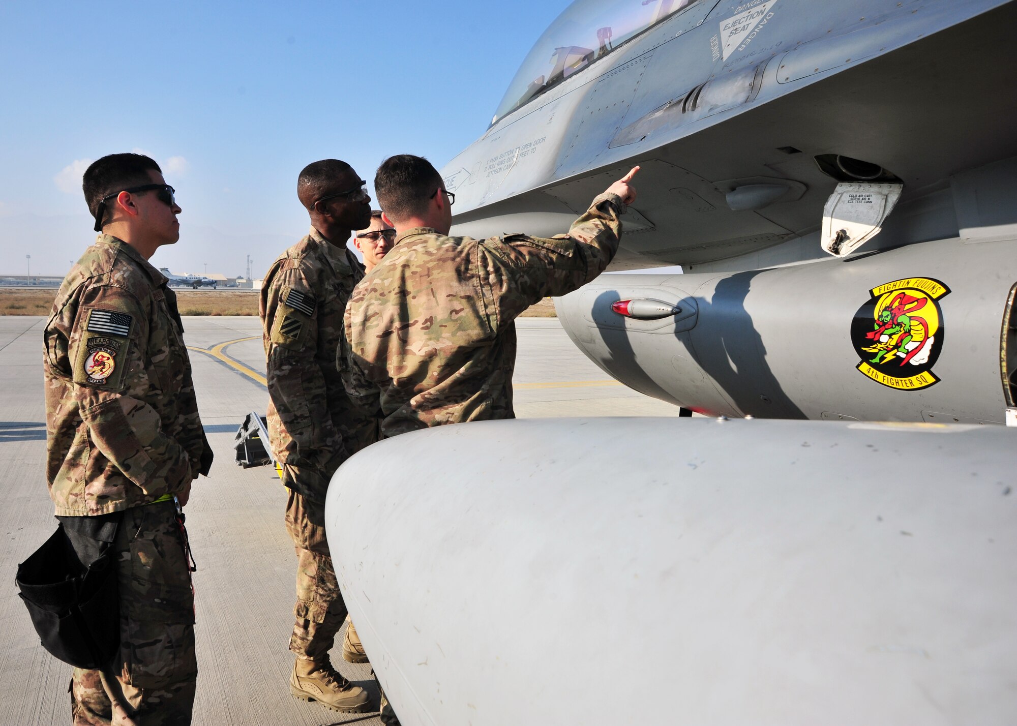 U.S. Air Force Senior Airman Andrew Freire, 455th Expeditionary Aircraft Maintenance Squadron weapons troop, briefs U.S. Army Command Sgt. Maj. Christopher Gilpin, Combined Joint Task Force 3 United States Forces Afghanistan, during a tour Jan. 6, 2015 at Bagram Airfield, Afghanistan. During the tour, Gilpin had the opportunity to meet with 455th Air Expeditionary Wing leadership and become better acquainted with Air Force assets and squadrons. (U.S. Air Force photo by Staff Sgt. Whitney Amstutz/released)
