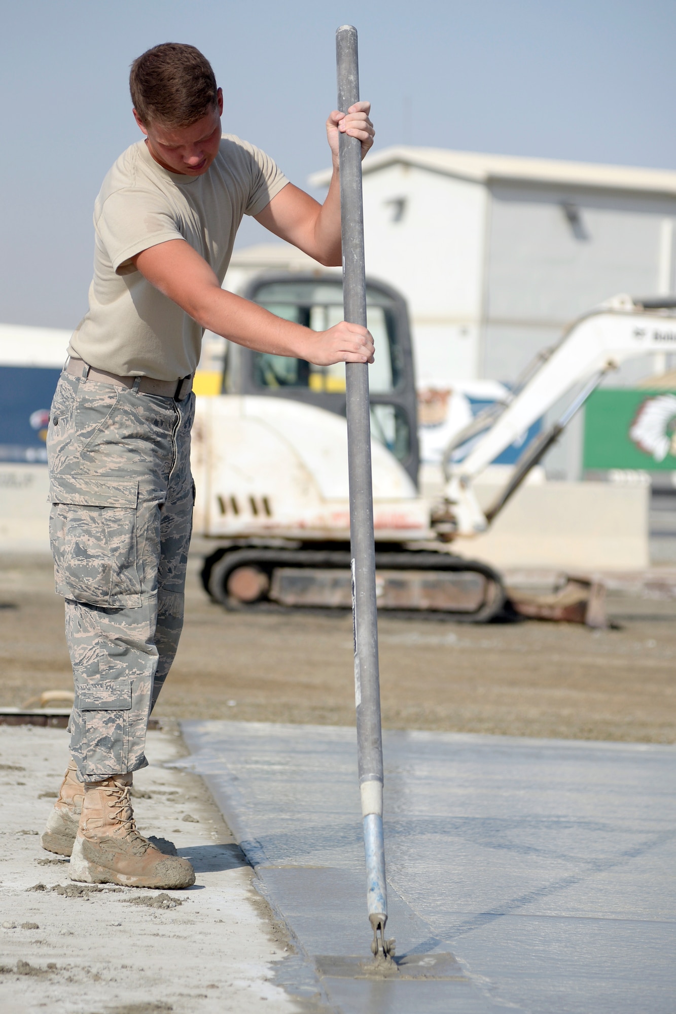 Airman 1st Class Joshua, Expeditionary Civil Engineer Squadron, works on a new concrete pad at the new Australian beddown site at an undisclosed location in Southwest Asia Oct. 30, 2014. Airmen with the ECES worked side-by-side with their Australian counterparts to construct 35 tents. (U.S. Air Force photo/Tech. Sgt. Marie Brown)