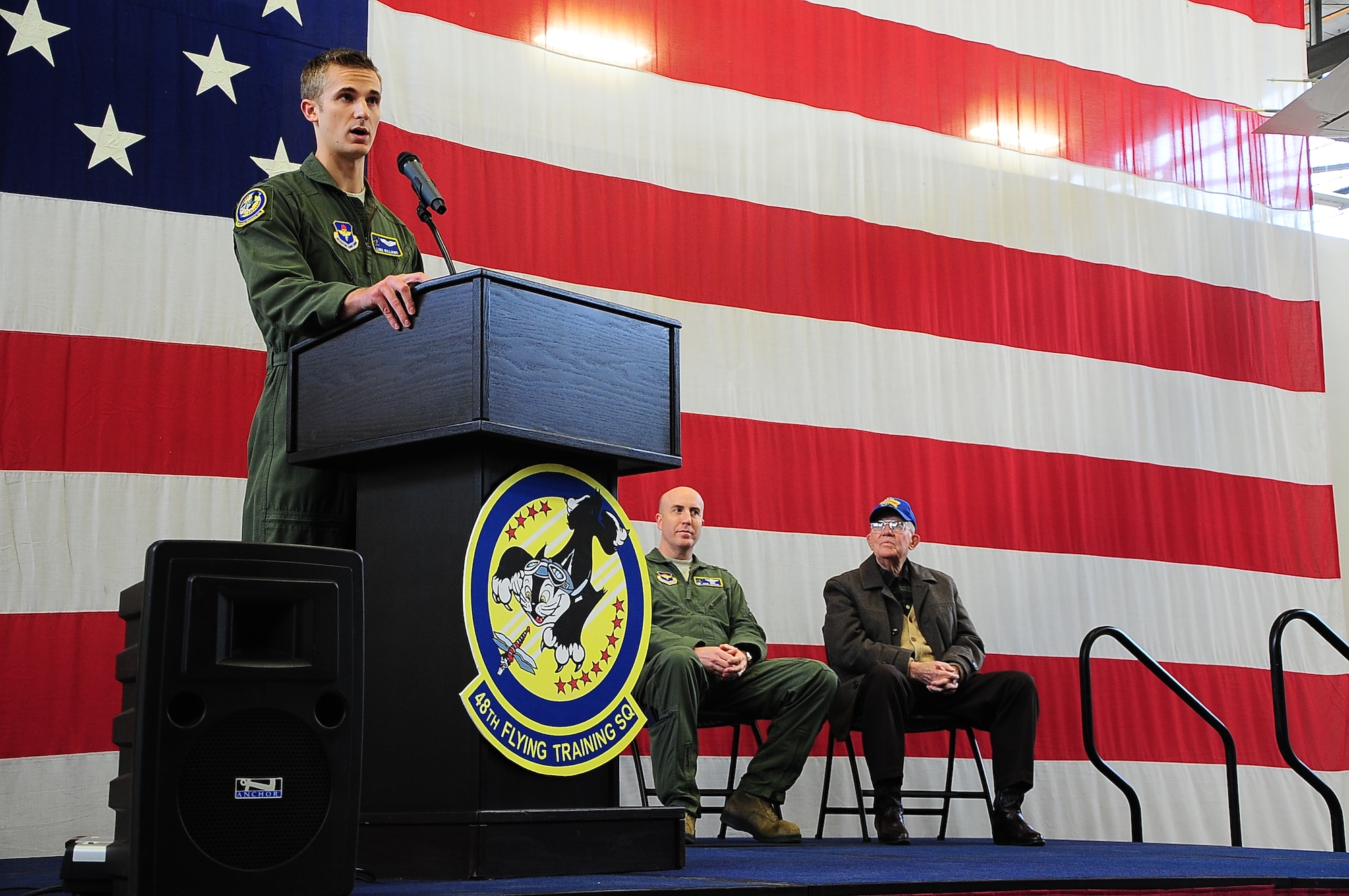 First Lt. Luke Williams, 48th Flying Training Squadron Instructor Pilot, Lt. Col. Paul Baker, 48th FTS Commander, and Air Force retired Col. Bob Jessup, a previous member of the 48th FIS, speak during the 48th FTS’s tail flash unveiling ceremony Jan. 9 in the Walker Center at Columbus Air Force Base, Mississippi. The speakers, all proud members of the 48th, showed their immense pride for their squadron in the form of personal stories and historic tales of past Airmen. (U.S. Air Force photo/Airman John Day)