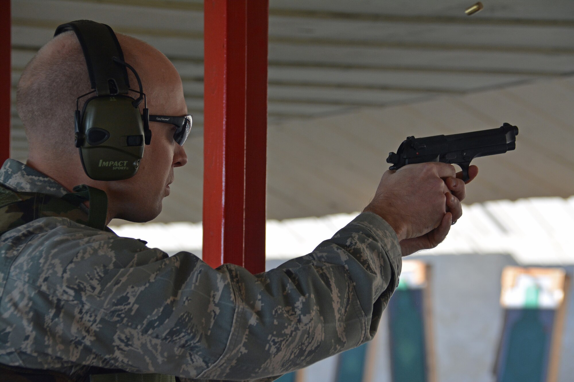 A round flies through the air after an Airman fires the M-9 pistol Jan. 6, 2015, at the Combat Arms firing range on Travis Air Force Base, California. (U.S. Air Force photo by Nick DeCicco)