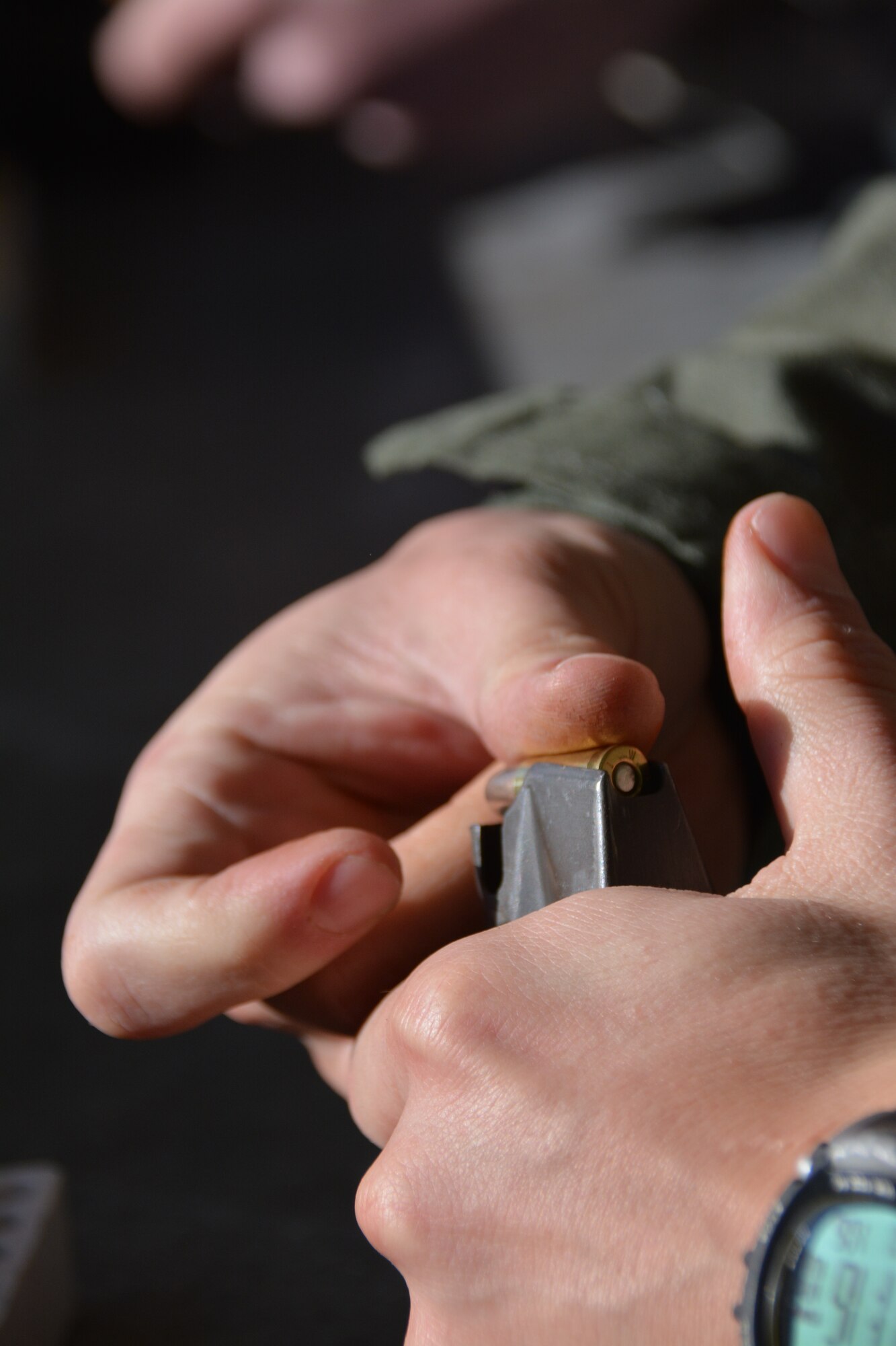 An Airman chambers a round into the magazine prior to shooting an M-9 pistol Jan. 6, 2015, at the Combat Arms firing range on Travis Air Force Base, California. Airmen learned to fire rounds from multiple angles in order to improve their overall skill. (U.S. Air Force photo by Nick DeCicco)