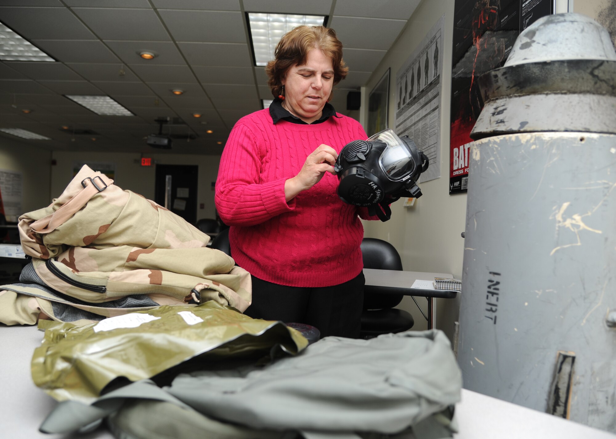 Roseanne Peterson, Base Operations Support emergency manager, conducts an inspection on an M-50 chemical mask prior to the start of the chemical, biological, radiological and nuclear class Jan. 9, 2015, at the civil engineering compound, Keesler Air Force Base, Miss.  Peterson was recently awarded the Defense Department certification in the emergency management field. (U.S. Air Force photo by Kemberly Groue)