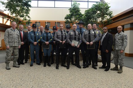 Col. Dan Merry, Air Force Mortuary Affairs Operations commander, and Chief Master Sgt. Rabin Ramsook, AFMAO chief enlisted manager, pose with personnel from the Delaware State Police and Dover Police Department Jan. 9, 2015, at the Charles C. Carson Center for Mortuary Affairs, Dover Air Force Base, Del. The commander presented certificates of appreciation for their support of the mortuary mission in honor of National Law Enforcement Appreciation Day. (U.S. Air Force photo/Staff Sgt. Nikoletta Kanakis) 