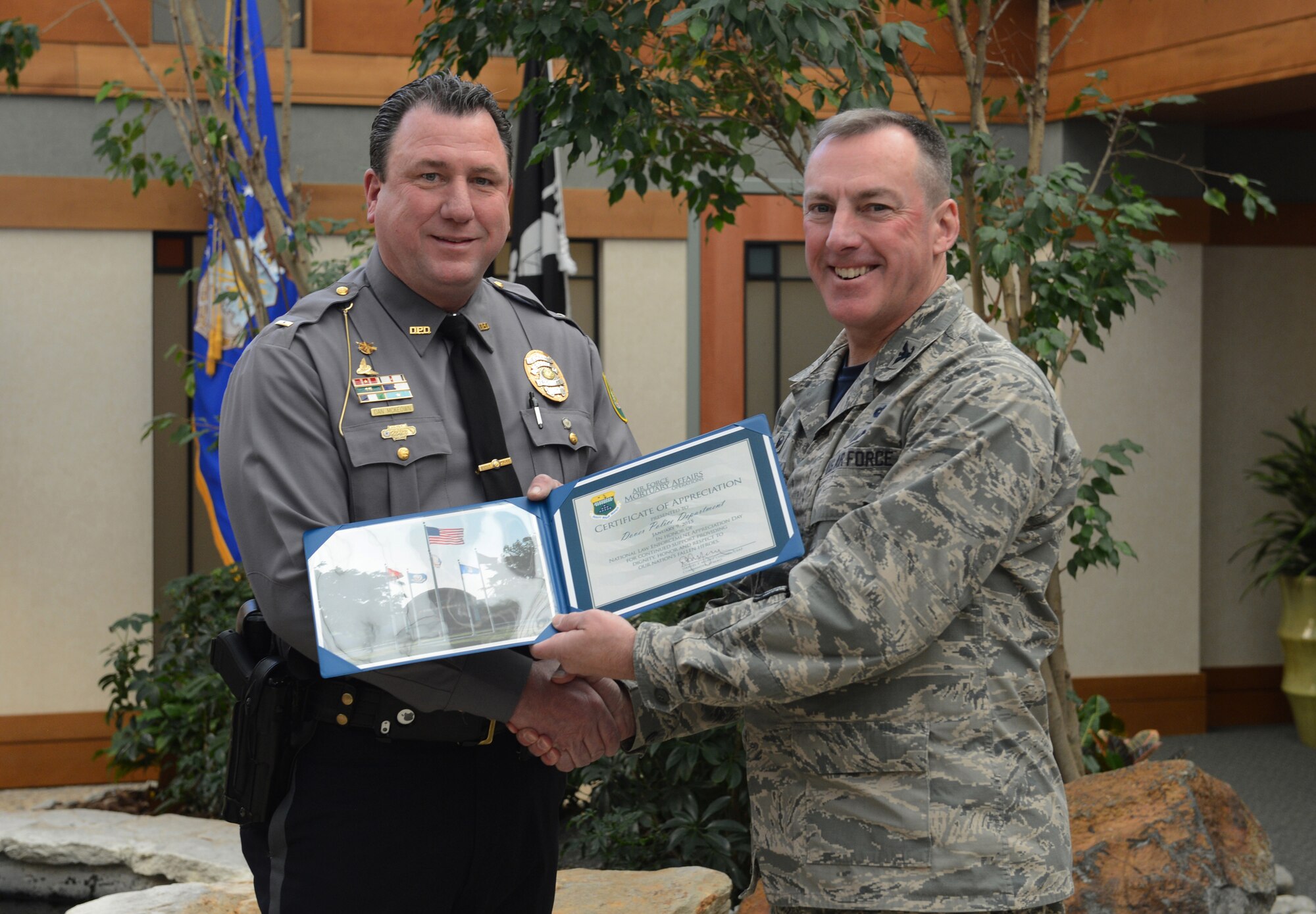 Col. Dan Merry, Air Force Mortuary Affairs Operations commander, presents a certificate of appreciation for the Dover Police Department to Lt. Dan McKeown Jan. 9, 2015, to recognize them for their support of the mortuary mission on National Law Enforcement Day. Several officers from the Dover Police Department assist as police escorts for fallen service members leaving the port mortuary. (U.S. Air Force photo/Staff Sgt. Nikoletta Kanakis) 