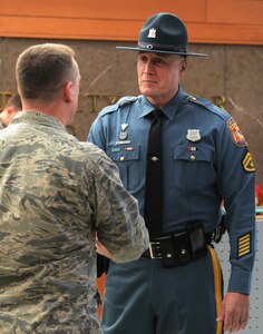 Col. Dan Merry, Air Force Mortuary Affairs Operations commander, greets Delaware State Trooper Master Cpl. Gary Fournier Jan. 9, 2015, in the atrium of the Charles C. Carson Center for Mortuary Affairs, Dover Air Force Base, Del. Fournier has served as a police escort for fallen service members leaving the port mortuary. (U.S. Air Force photo/Staff Sgt. Nikoletta Kanakis) 