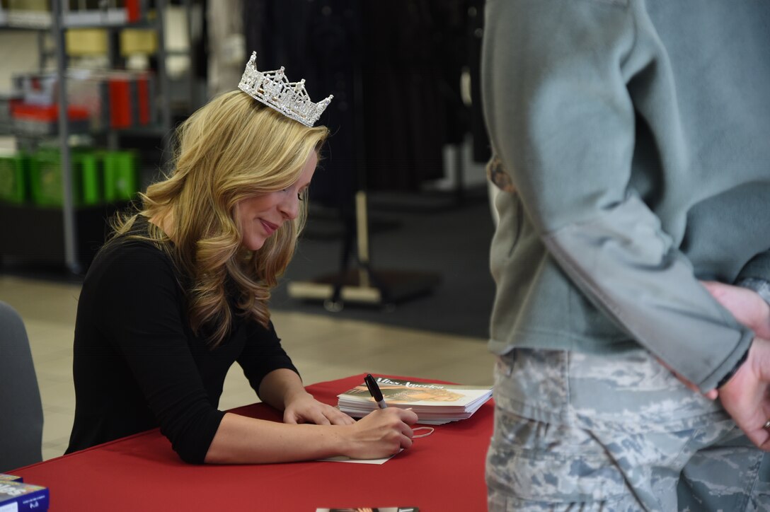 Kira Kazantsev, 2015 Miss America, signs autographs for fans at the Base Exchange on Joint Base Andrews, Md. on Jan. 8, 2015. Kazantsev visited the JBA with the USO to take photos with the JBA community and sign photographs as a way to give thanks to service members for their service. (U.S. Air Force photo/ Airman 1st Class J.D. Maidens)