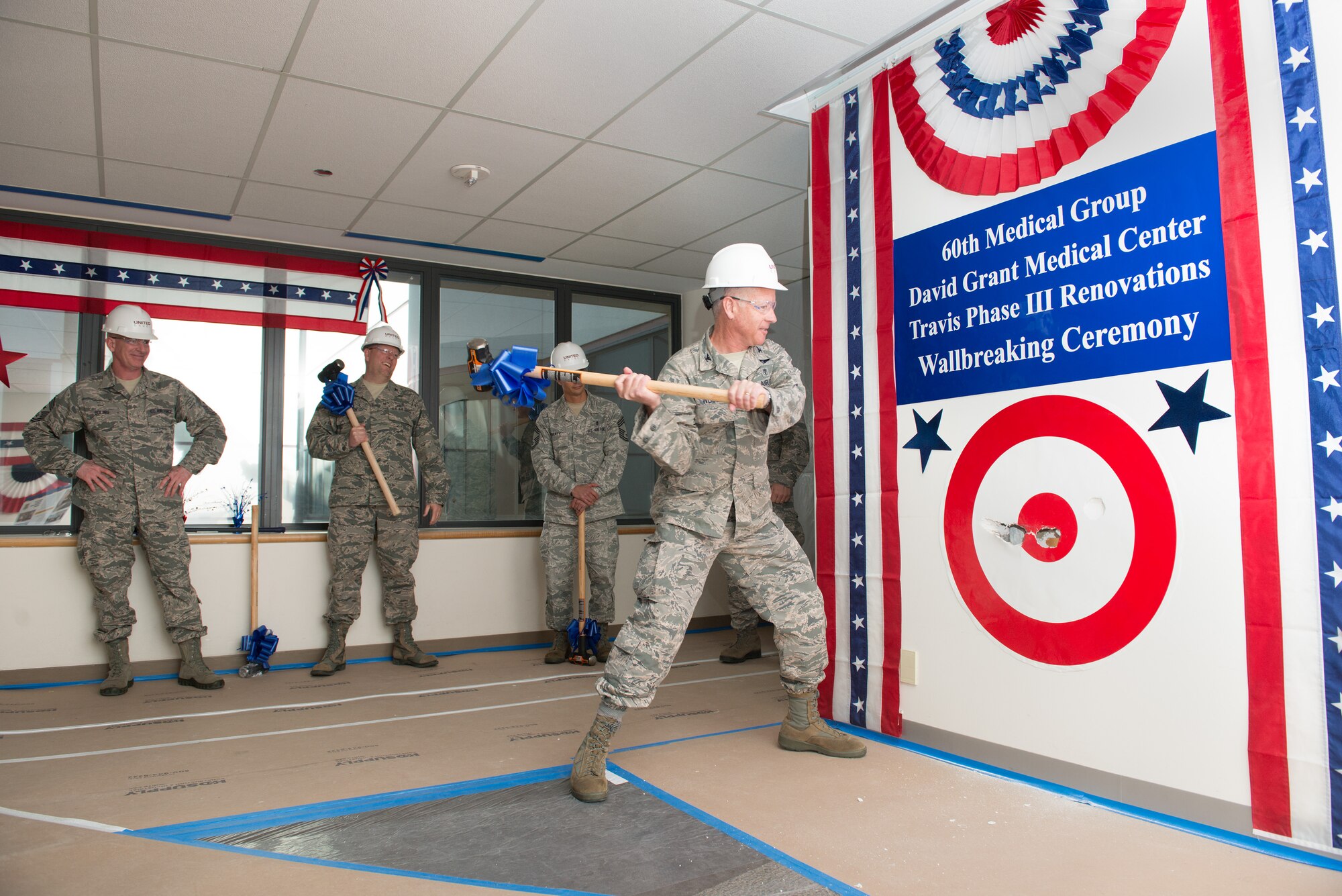 Col. (Dr.) Rawson Wood, 60th Medical Group commander, swings a sledge hammer during a ceremonial wall-breaking Jan. 6, 2015, at David Grant USAF Medical Center. The ceremony marked the start of Travis Air Force Base's Phase III Main Project that will increase operating room capacity and vastly improve the Labor and Delivery unit. (U.S. Air Force photo by Ken Wright) 