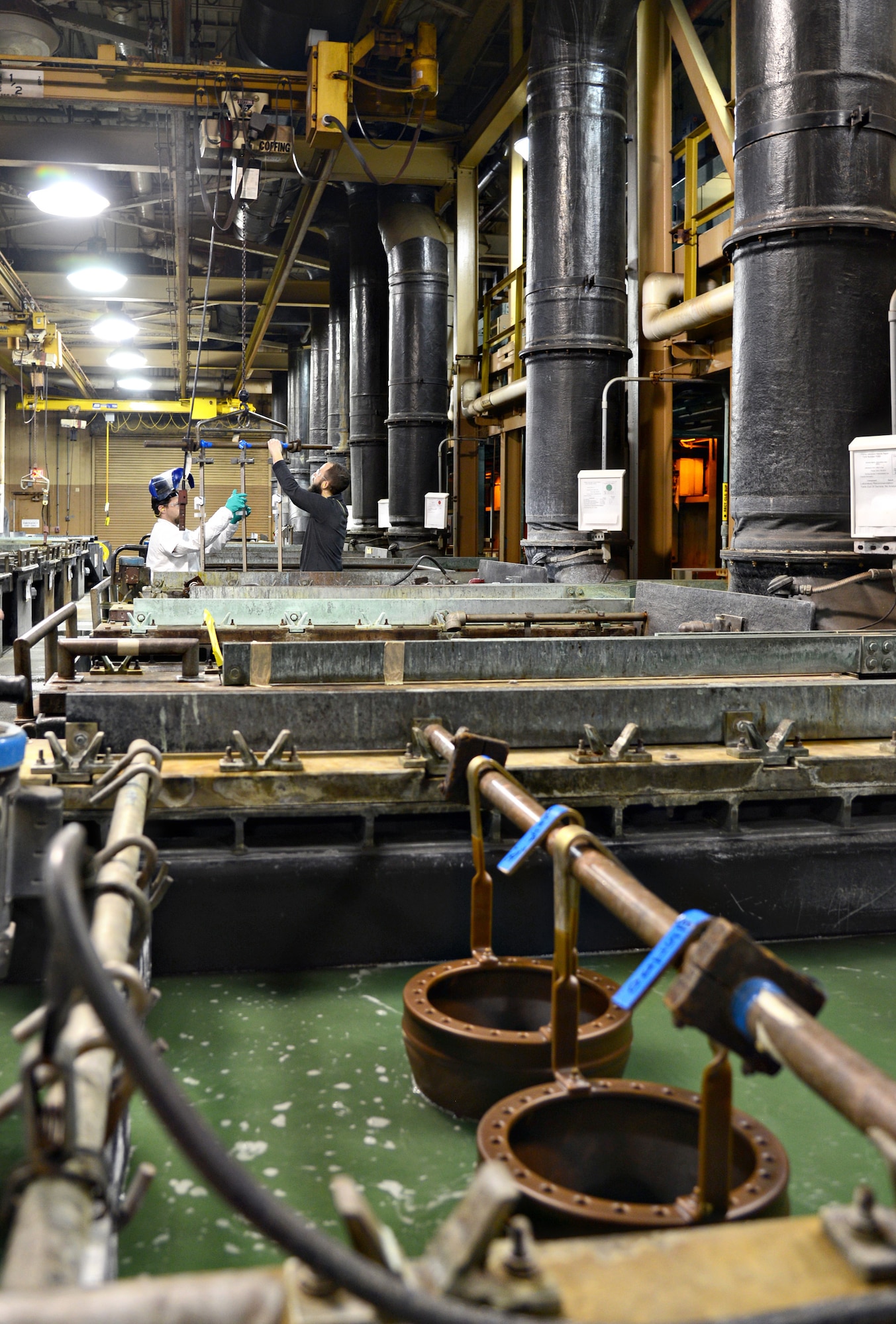 Dean Sims and Ed McLaughlin prepare fixtures to attach flaps for electrochemical stripping with a Rochelle salt solution. Mr. Sims is an electroplater and Mr. McLaughlin is a process engineer, both with the 76th Propulsion Maintenance Group. (Air Force photo by Kelly White)