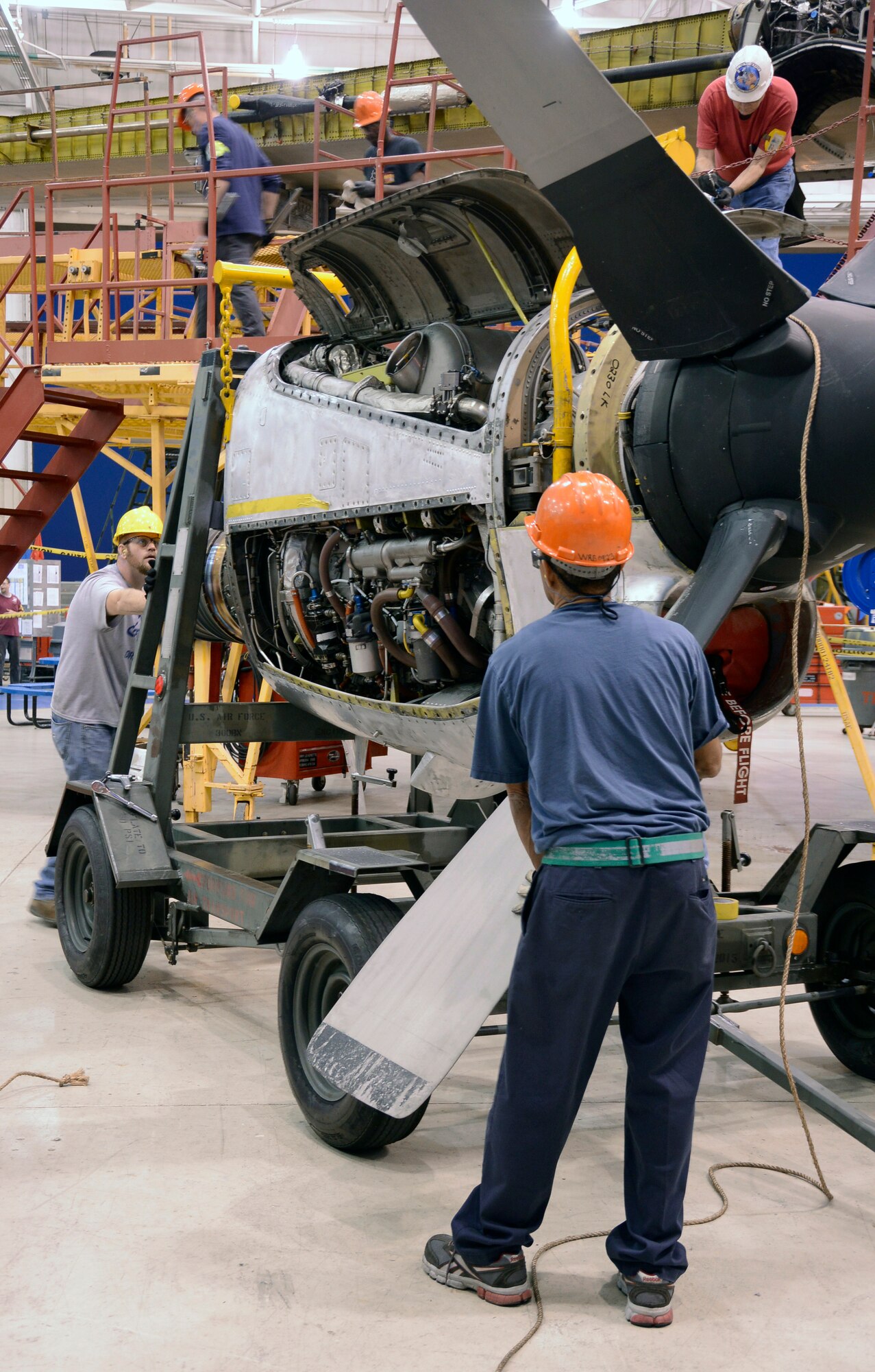 Patrick Dixon, left, and Ronald DeFreitas, both C-130 mechanics, move an outboard engine which has been removed for maintenance during the PDM process. (U.S. Air Force photo by Ed Aspera)