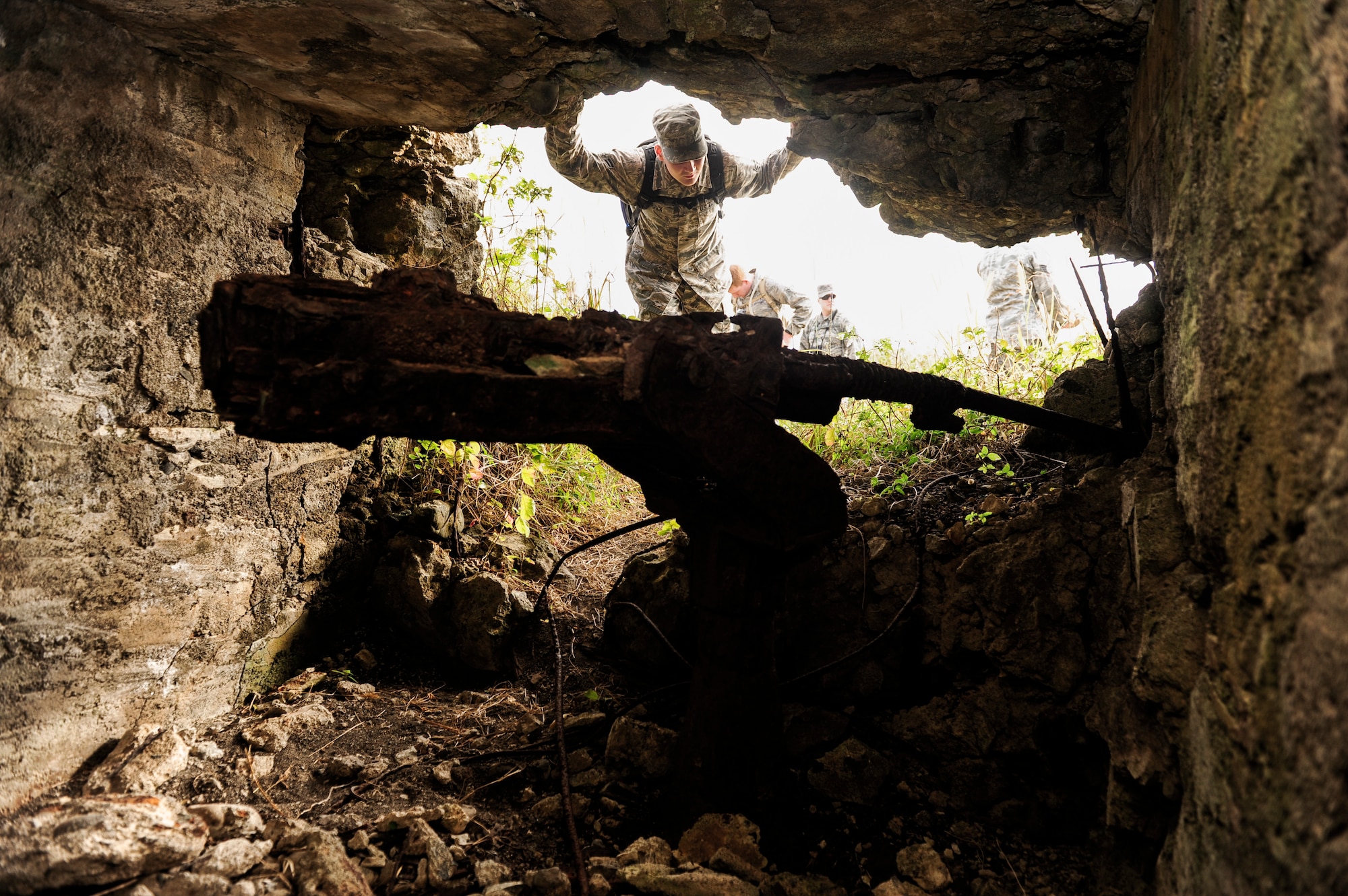 Airman 1st Class Jose Herrick, 18th Wing Judge Advocacy paralegal, peeks into the ruins of a Japanese bunker used during World War II, Jan. 8, 2015, on Iwo To, Japan. The U.S. Marine Corps led a 36-day assault on the island during the Battle of Iwo Jima. Japanese forces hid machinegun nests and other artillery weaponry to deter the invading Marines. (U.S. Air Force photo by Airman 1st Class John Linzmeier)