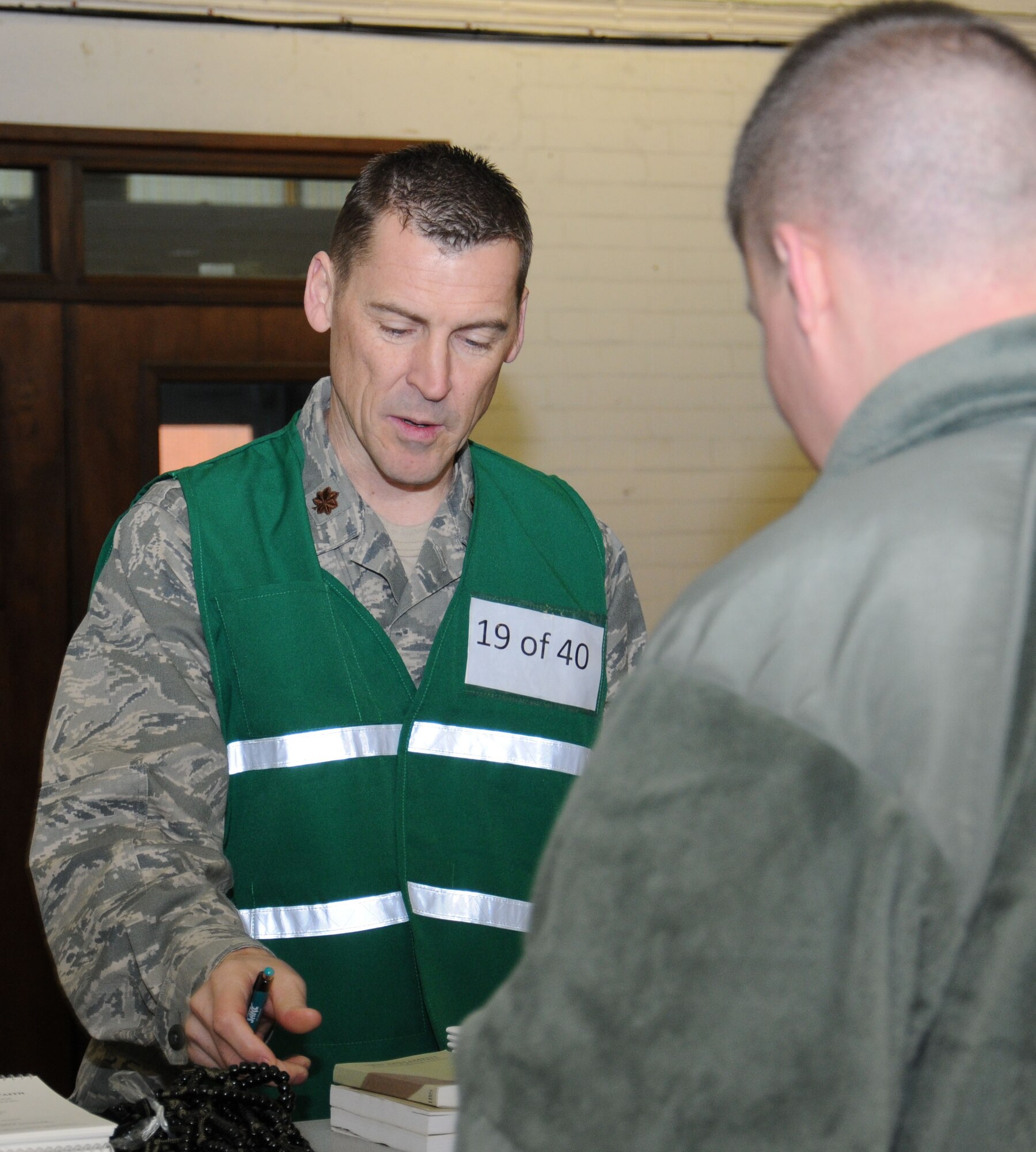 U.S. Air Force Chaplain (Maj.) Randy Croft, left, 100th Air Refueling Wing deputy chaplain, speaks with a Team Mildenhall member as he goes through the personnel deployment function line during an operational readiness exercise Jan. 7, 2015, on RAF Mildenhall, England. The exercise involved a three-part process in which participants first were issued bags and equipment from the mobility section, then went through the PDF line, followed by a briefing so leadership could get an understanding of the group’s preparedness and concerns. (U.S. Air Force photo by Gina Randall/Released)