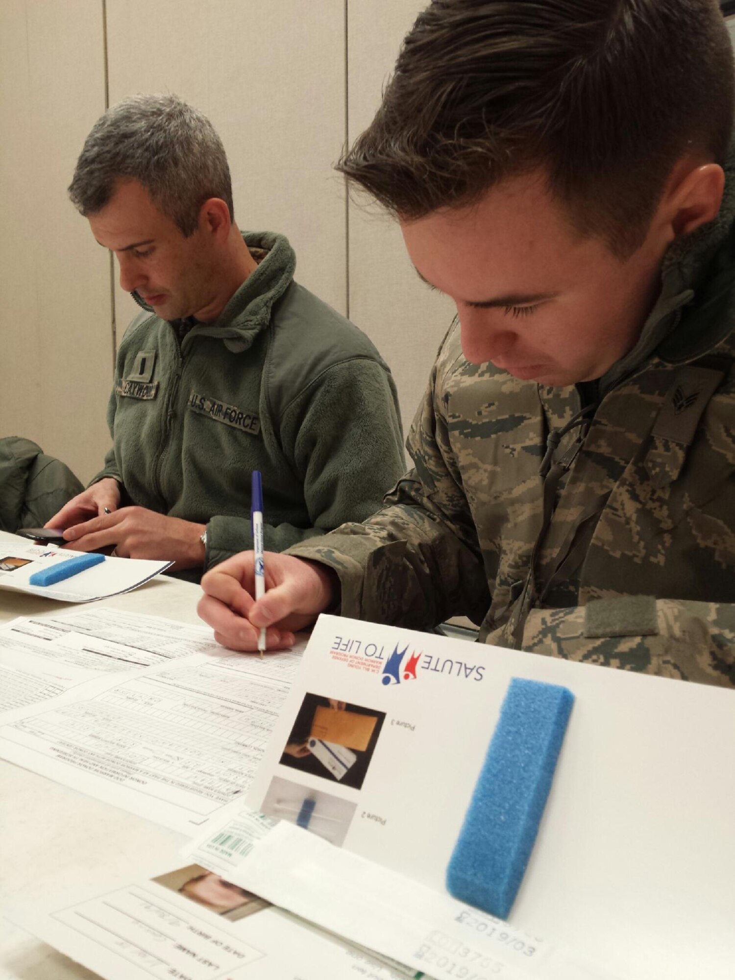U.S. Air Force Chaplain, 1st Lt. Robert Caywood, a chaplain with the 180th Fighter Wing, and Senior Airman Nathan Cousino, 180th FW Chaplains Assistant, filled out consent forms during the wing's two-day bone marrow registration drive Jan. 10 2015, part of the Salute to Life Program. The Salute to Life Program, also known as the C.W. Bill Young/Department of Defense Marrow Donor Program, works with active duty and their dependents, guard, reservist and Department of Defense civilian employees to facilitate marrow and stem cell donations. All of the donors are volunteers and since the program’s inception in 1991, more than 750,000 individuals to fight against blood cancer and other fatal diseases.  Air National Guard photo by Senior Master Sgt. Beth Holliker (Released)