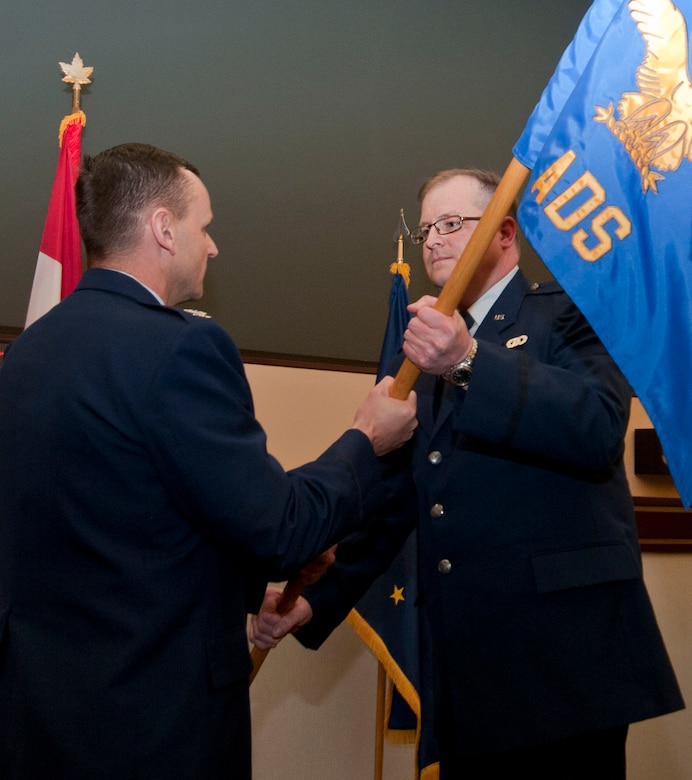 JOINT BASE ELMENDORF-RICHARDSON, Alaska - Lt. Col. Kevin Clifford (right) of the Alaska Air National Guard receives the 176th Air Defense Squadron's command flag from Col. Darrin Slaten, commander of the 176th Operations Group, in a ceremony here Jan. 10, 2015. National Guard photo by Capt. John Callahan.
