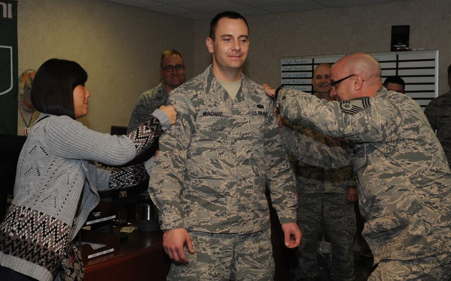 Staff Sgt. Sarah Merchant, left, Air Force Global Strike Command command chief executive assistant, and Chief Master Sgt. Gary Hunkins, right, 2nd Mission Support Group superintendent, pin new stripes on Staff Sgt. Merchant on Barksdale Air Force Base, La., Dec. 17, 2014. The newly promoted technical sgt. was the only Airmen across 8th Air Force to be promoted through the Stripes for Exceptional Performers program within this cycle. (U.S. Air Force photo/Senior Airman Kristin High)