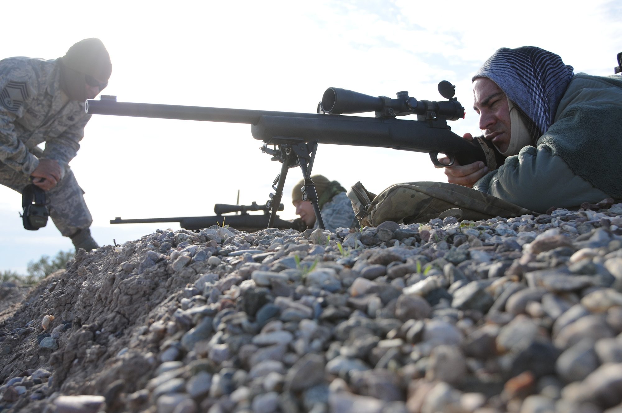 Chief Master Sgt. Emilio Rodriguez, Senior Airman Kyle Drzewiecki, and Staff Sgt. Robert Ehle, 161st Security Forces Squadron Advanced Designated Marksmen, hone their newly acquired skills at the shooting range in Florence, Ariz., Jan. 9, 2015. ADM Airmen, or “snipers”, deliver long-range direct fire out to 600 meters and provide enhanced situational awareness through observation and reporting in peacetime and contingency operations. The 161st Security Forces Squadron is one of only eight units of the more than 100 Air National Guard units which currently have trained/qualified advanced designated marksmen. To become a certified Air Force advanced designated marksman, Airmen must attend the ADM course at Ft. Bliss, El Paso, Texas. The 11-day course familiarizes Airmen with the M24 weapon system and teaches target detection, along with distance and windage estimation. The new ADM graduates said they are grateful for the invaluable time and knowledge of Chief Rodriguez, ADM trainer, who has nearly 35 years of both military and civilian experience, from being a Marine Corps scout sniper and an Army Special Forces sniper to running the Pittsburg SWAT team. “You can never know enough and you can never get enough training,” said Ehle. “We will never know as much as [Rodriguez] has forgotten.” (U.S. Air National Guard photo by Tech. Sgt. Courtney Enos/Released)