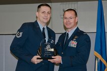 Col. Kevin Heer (right), Commander, 132nd Fighter Wing (132FW), Des Moines, Iowa, presents Tech. Sgt. Dylan Staples (left) with the 132FW NCO of the Year award at the 2014 Annual Awards Ceremony held at the Valley Community Center, West Des Moines, Iowa on Saturday, November 1, 2014.  Tech. Sgt. Staples has since been selected as the 2015 Iowa ANG Outstanding NCO of the Year.  (U.S. Air National Guard photo by Staff Sgt. Linda K. Burger/Released)
